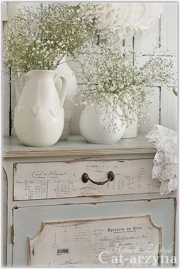 Lovely shabby chic bedroom decor with vintage dresser and fresh flowers 