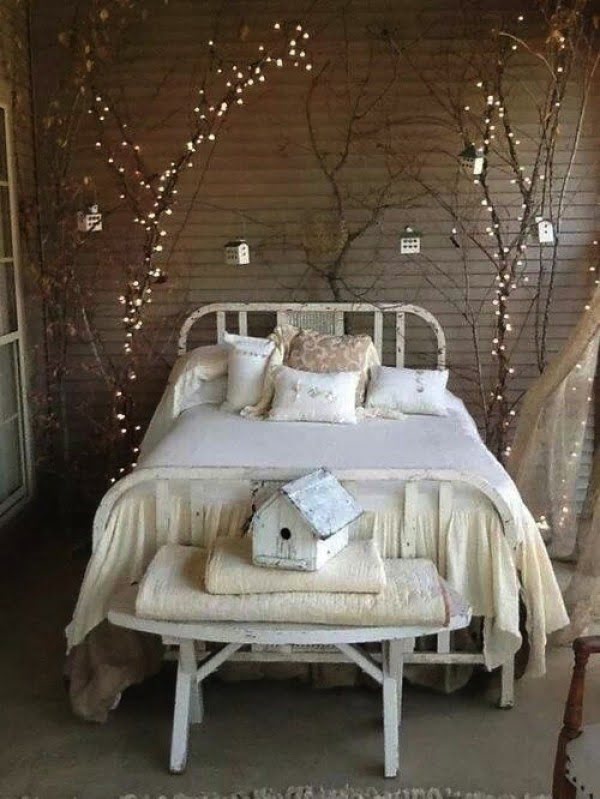 Love the bed decoration with tree branches and fairy lights 