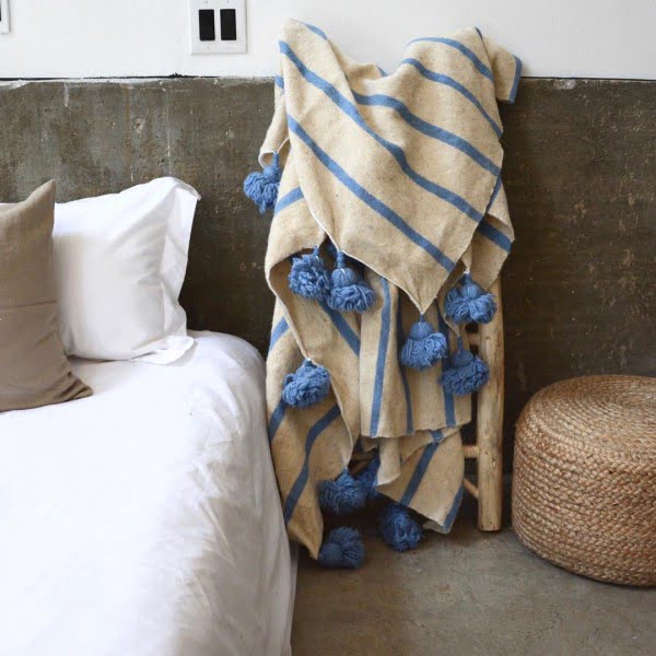 California chic decor idea with Moroccan blanket and rattan ottoman. Love it!