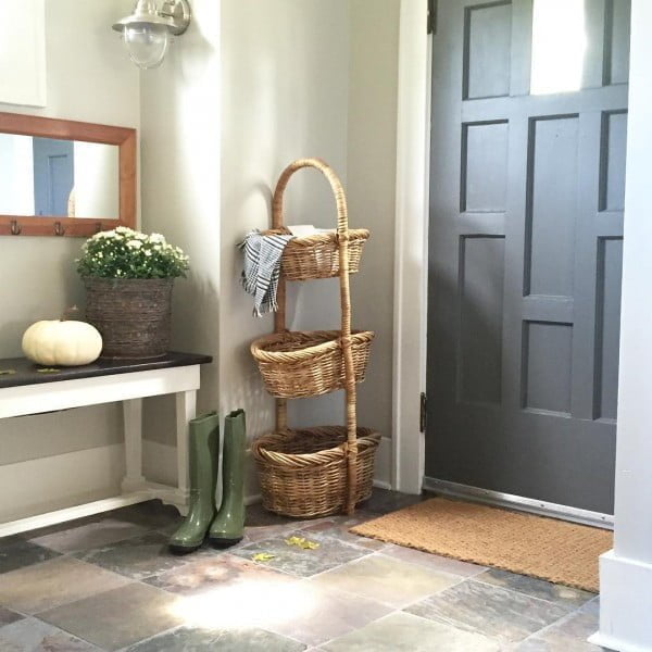 Check out this entryway decor idea with a tiered wicker basket. Love it!