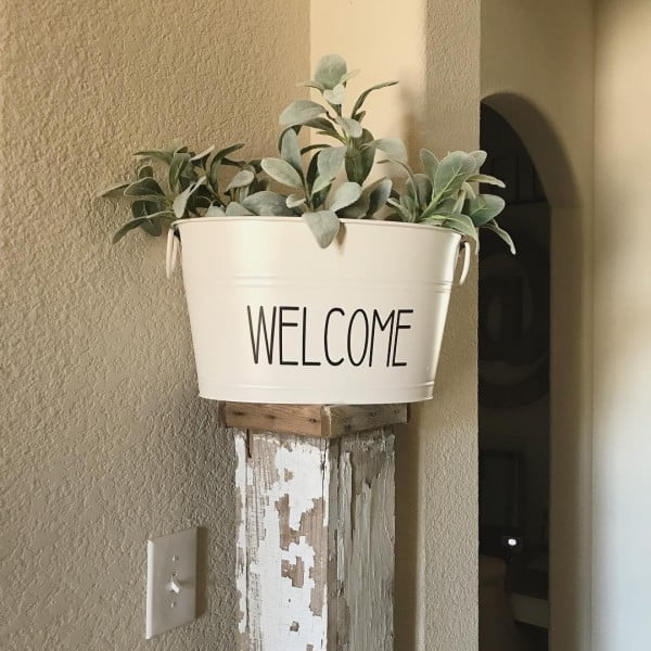 Check out this  entryway decor idea with a galvanized plant bucket. Love it! 