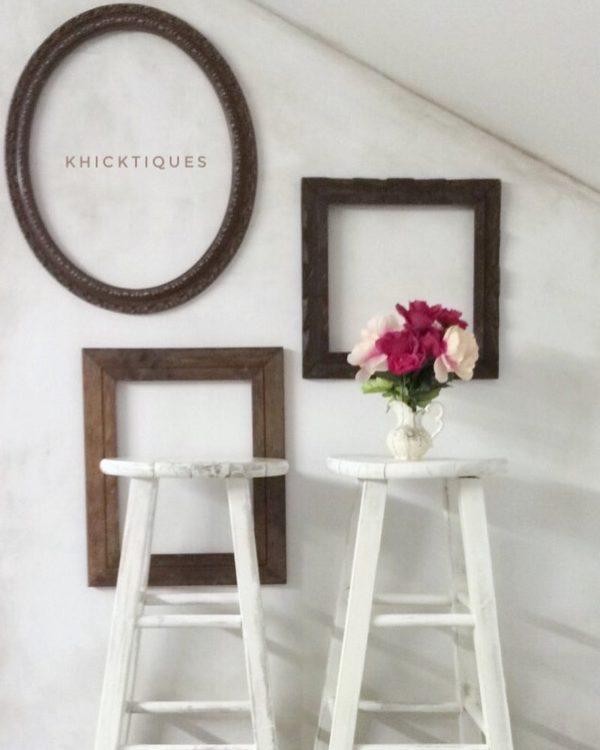  decor idea with a slanted backrgound wall and editorial blend of wooden photo frames. Love it!   