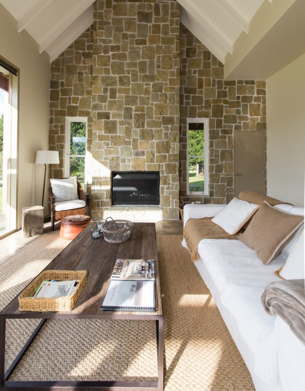 living room decor idea with detailed stone wall and barn-styled coffee table. Love it!