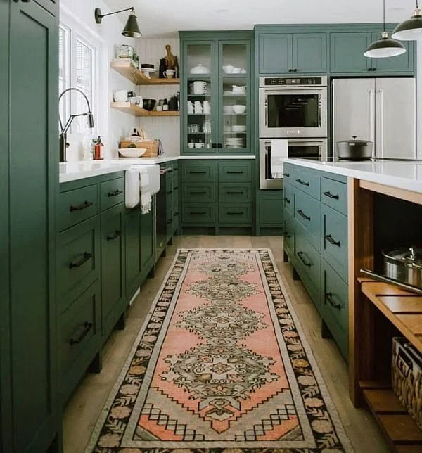 Teal green kitchen cabinets and an accent runner rug