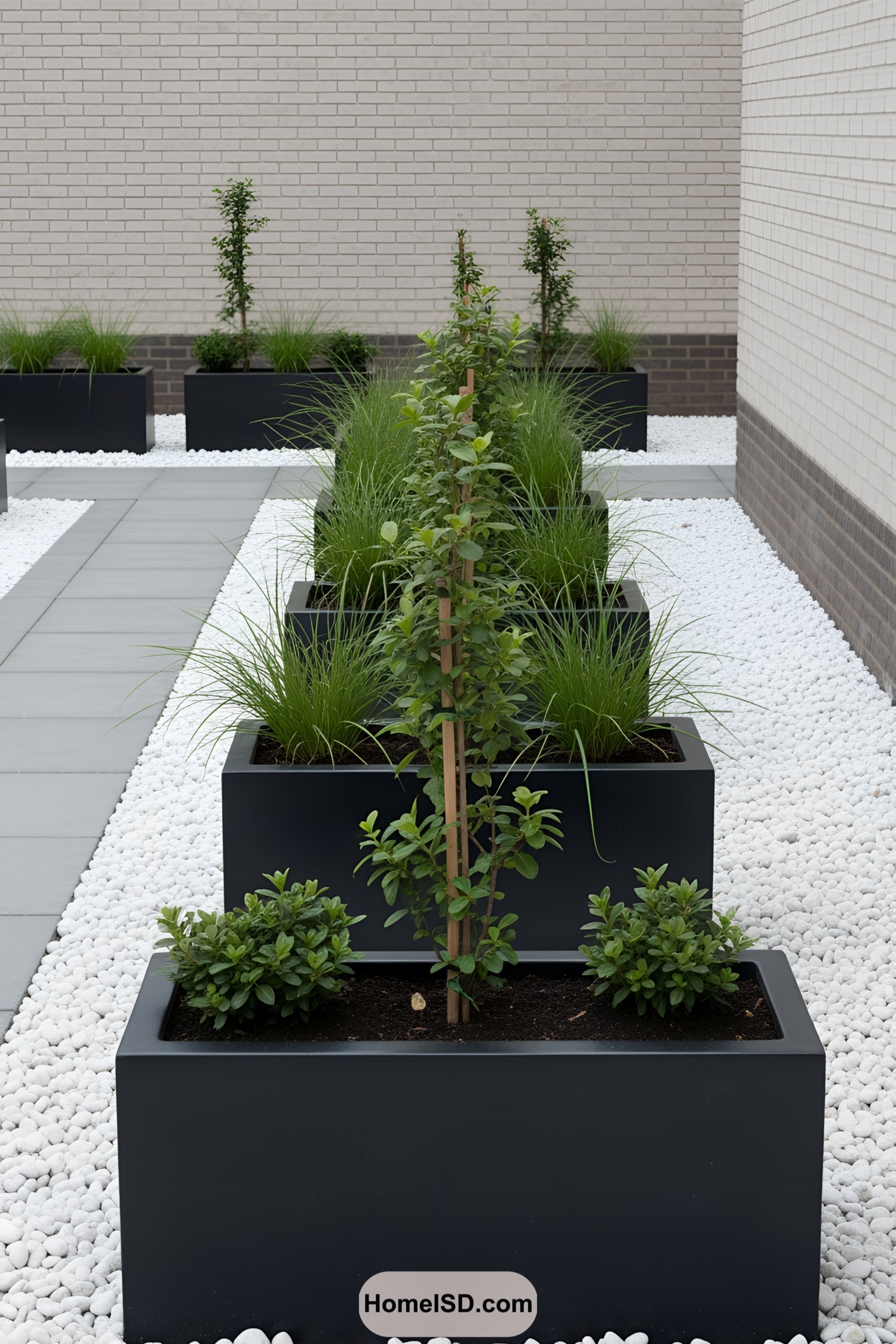 A modern garden with rectangular planters and white pebble stones