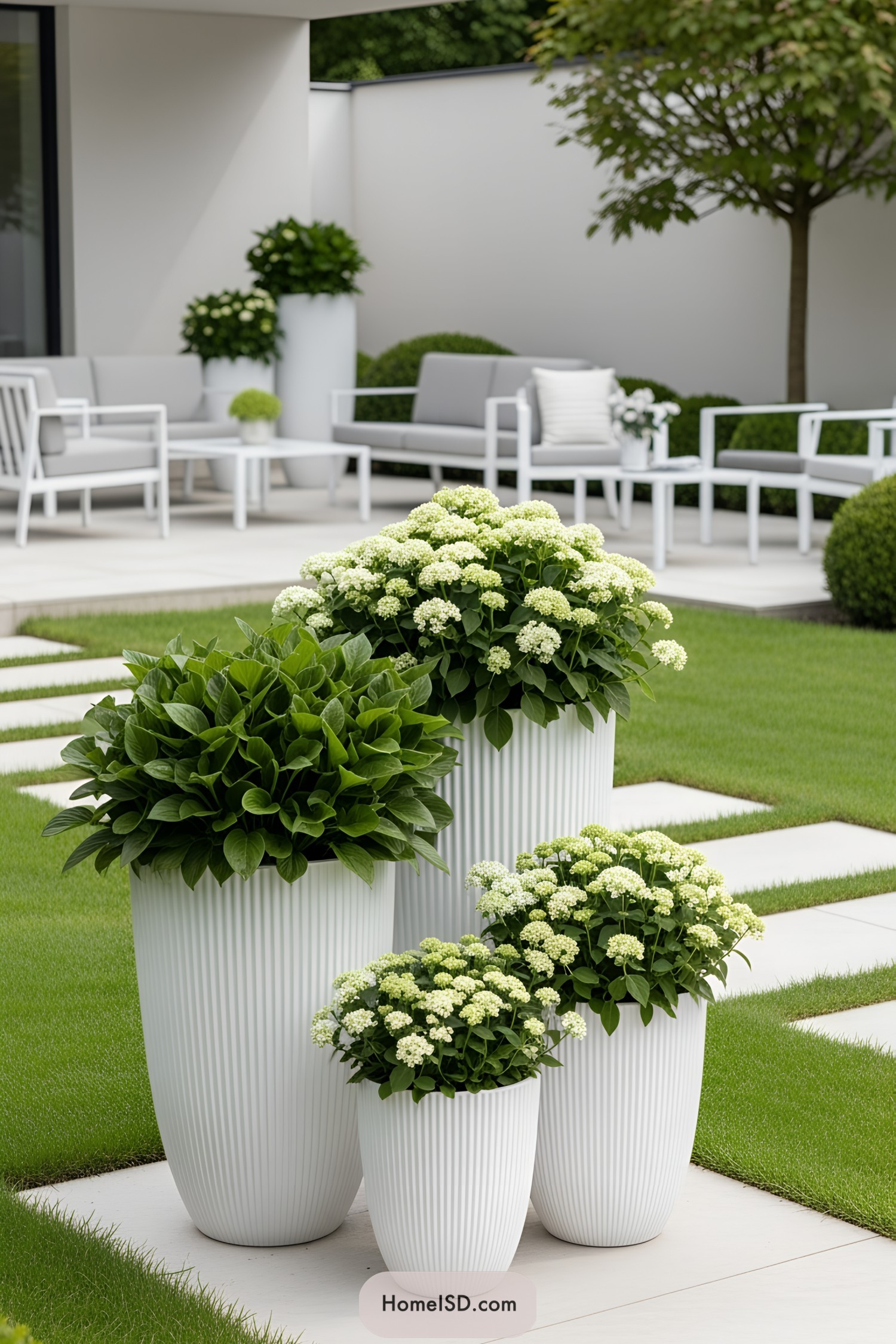 White flower pots with lush greenery in a modern garden setting