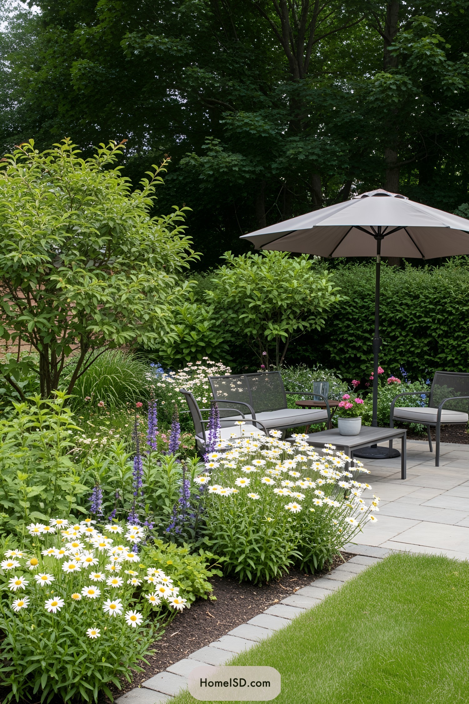 Outdoor seating area surrounded by lush greenery and bright flowers