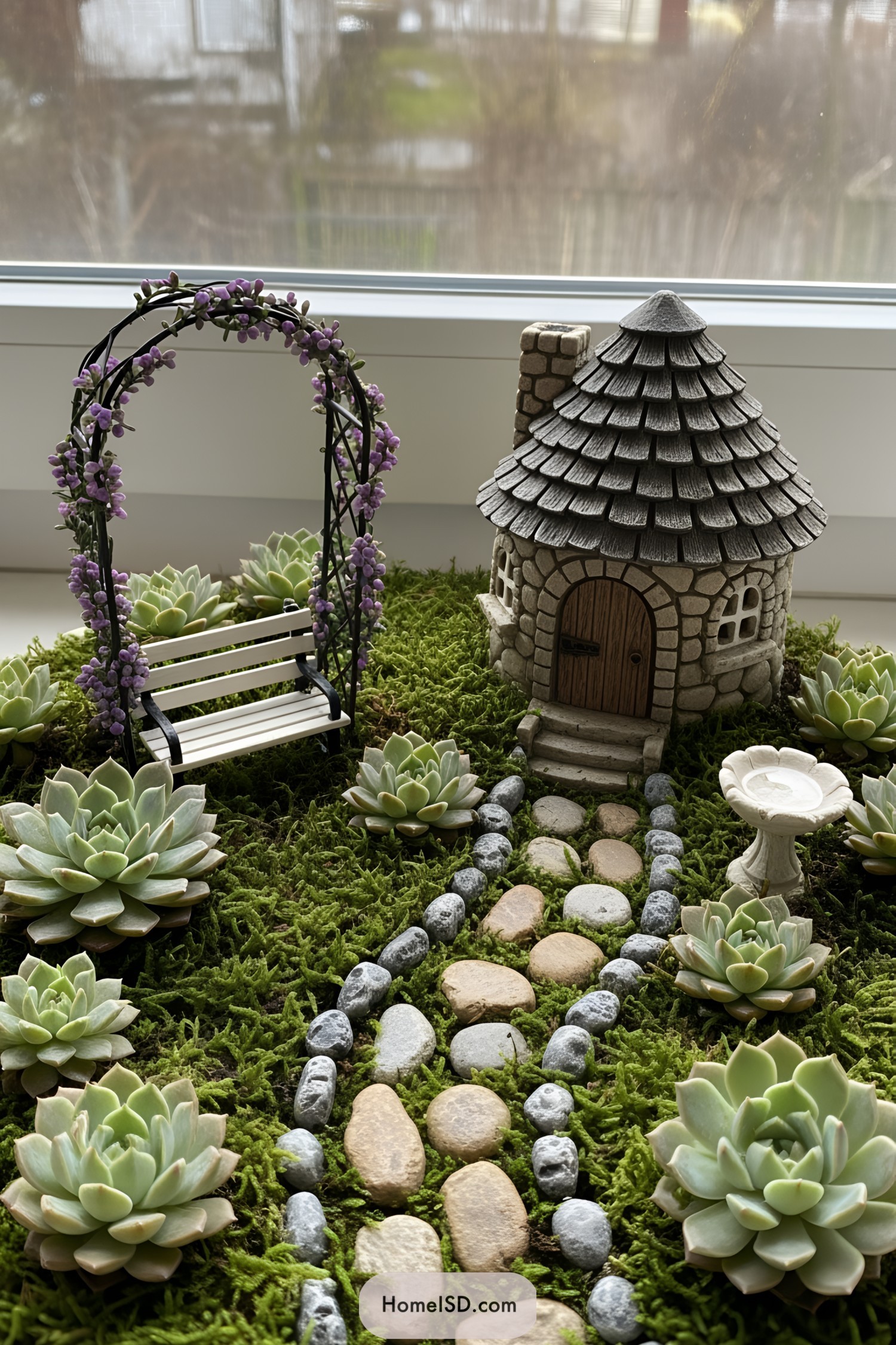 Miniature stone house with a garden path and arch
