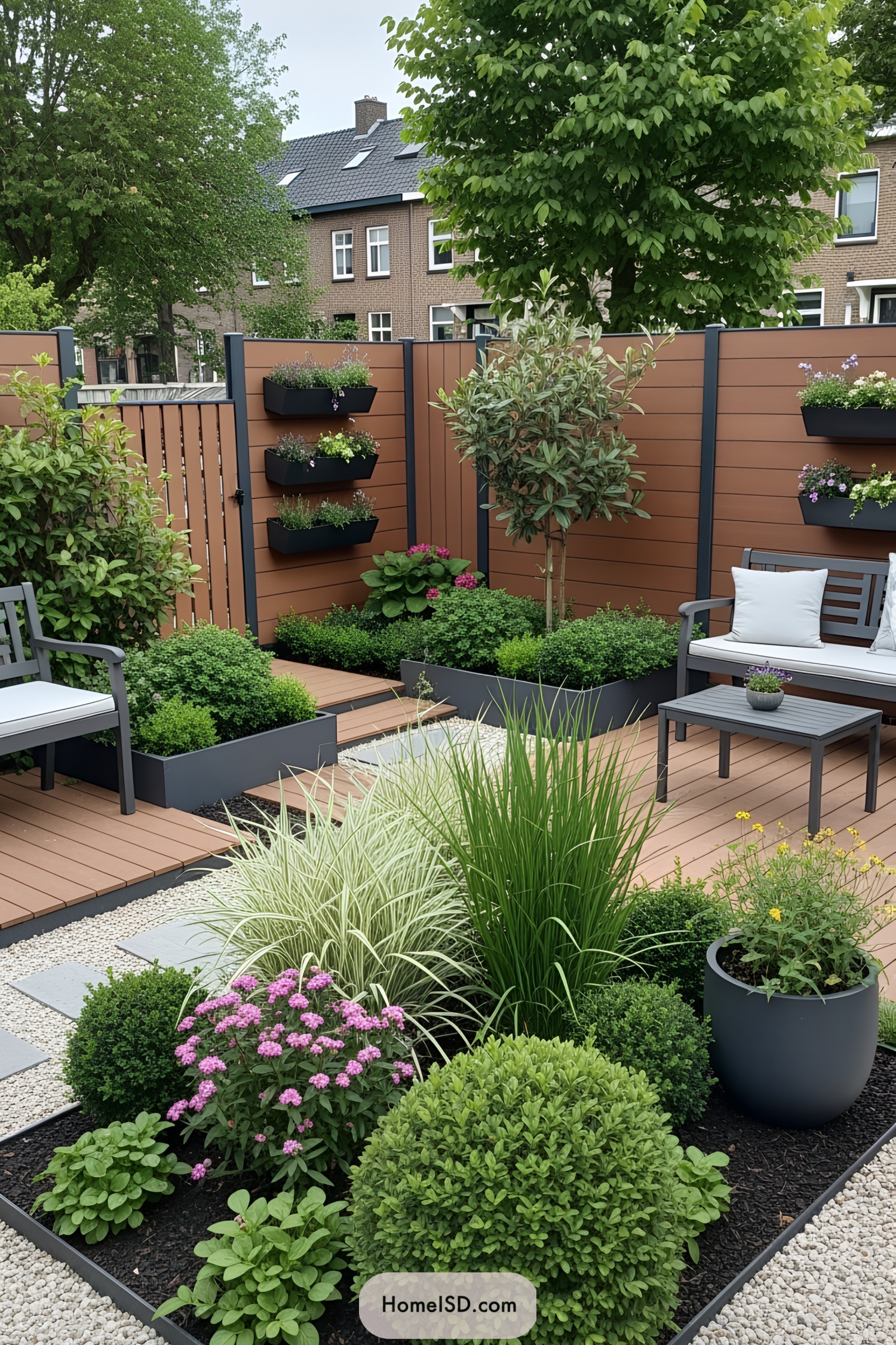 Small urban garden with wooden decking, lush plants, and cozy seating