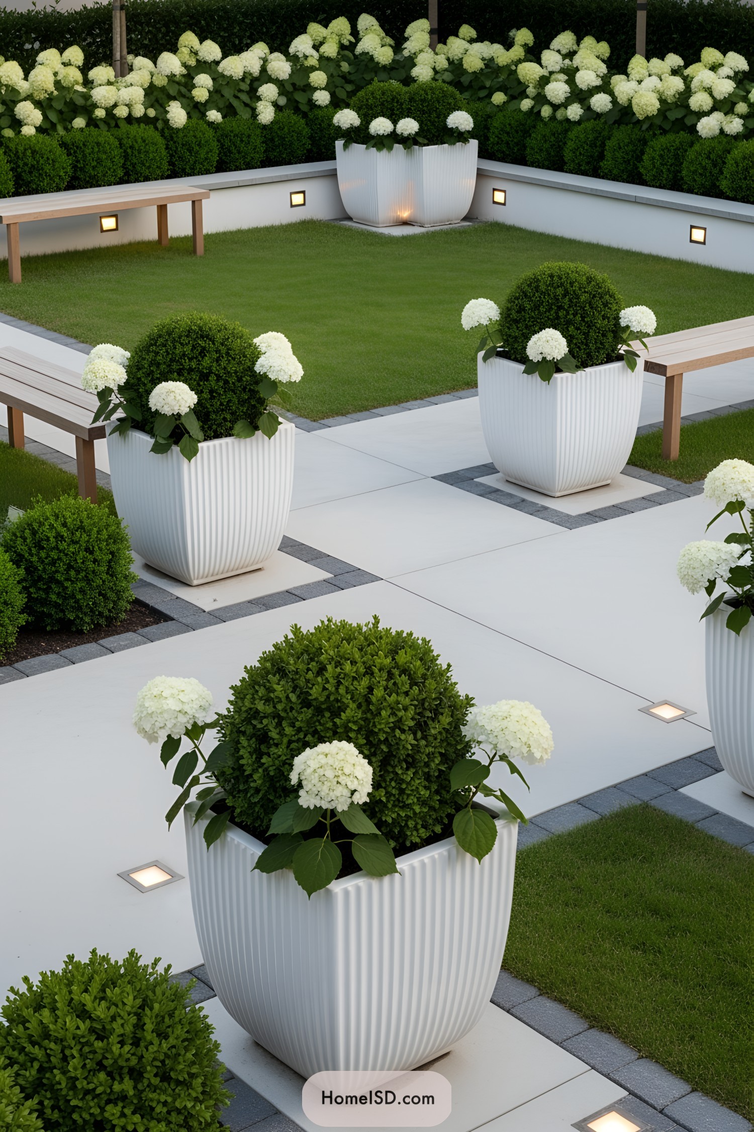 White flower pots with lush greenery in a modern garden