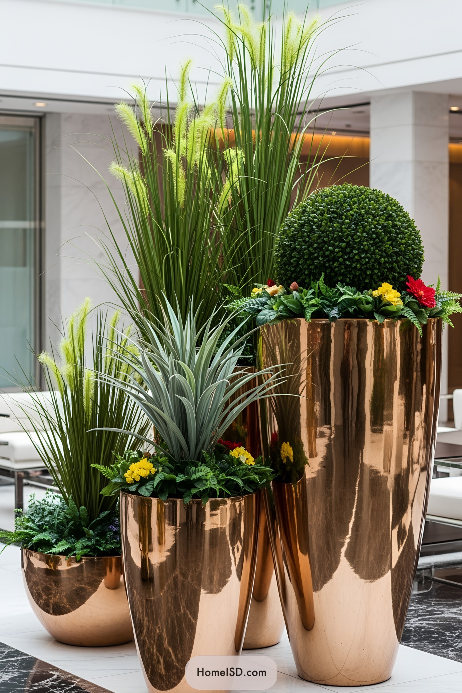 Towering bronze planters filled with vibrant plants