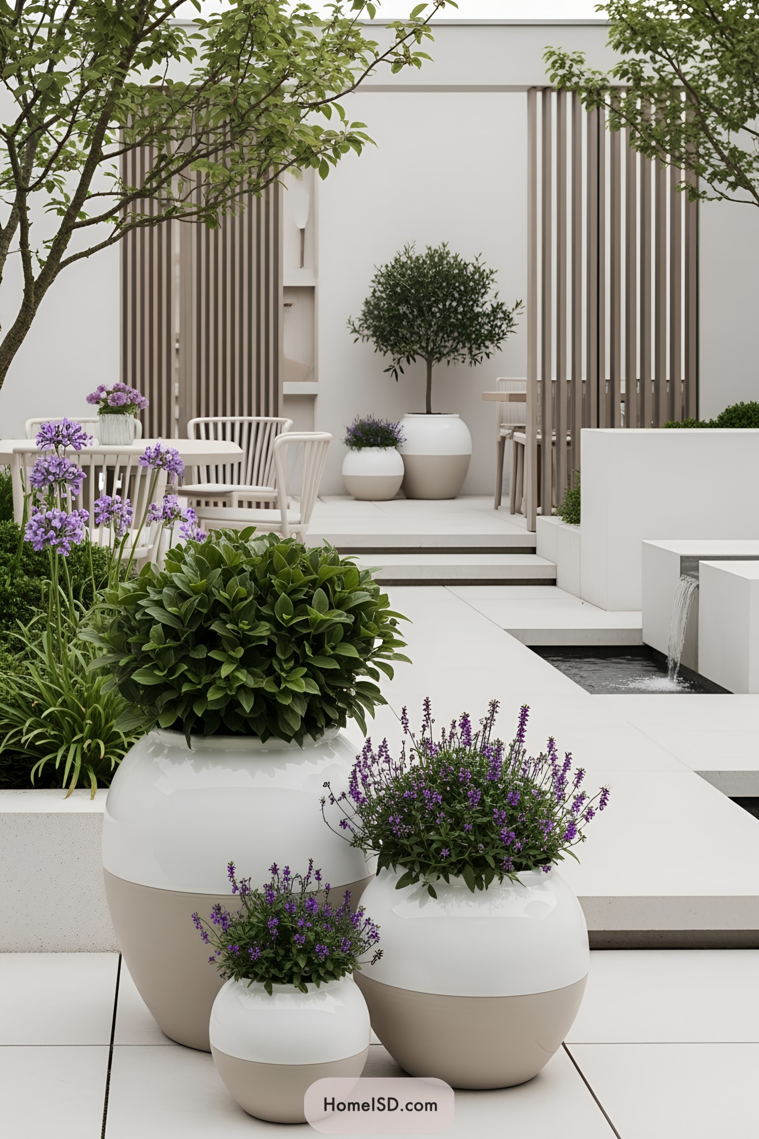 White planters adorn a chic courtyard with lush greenery