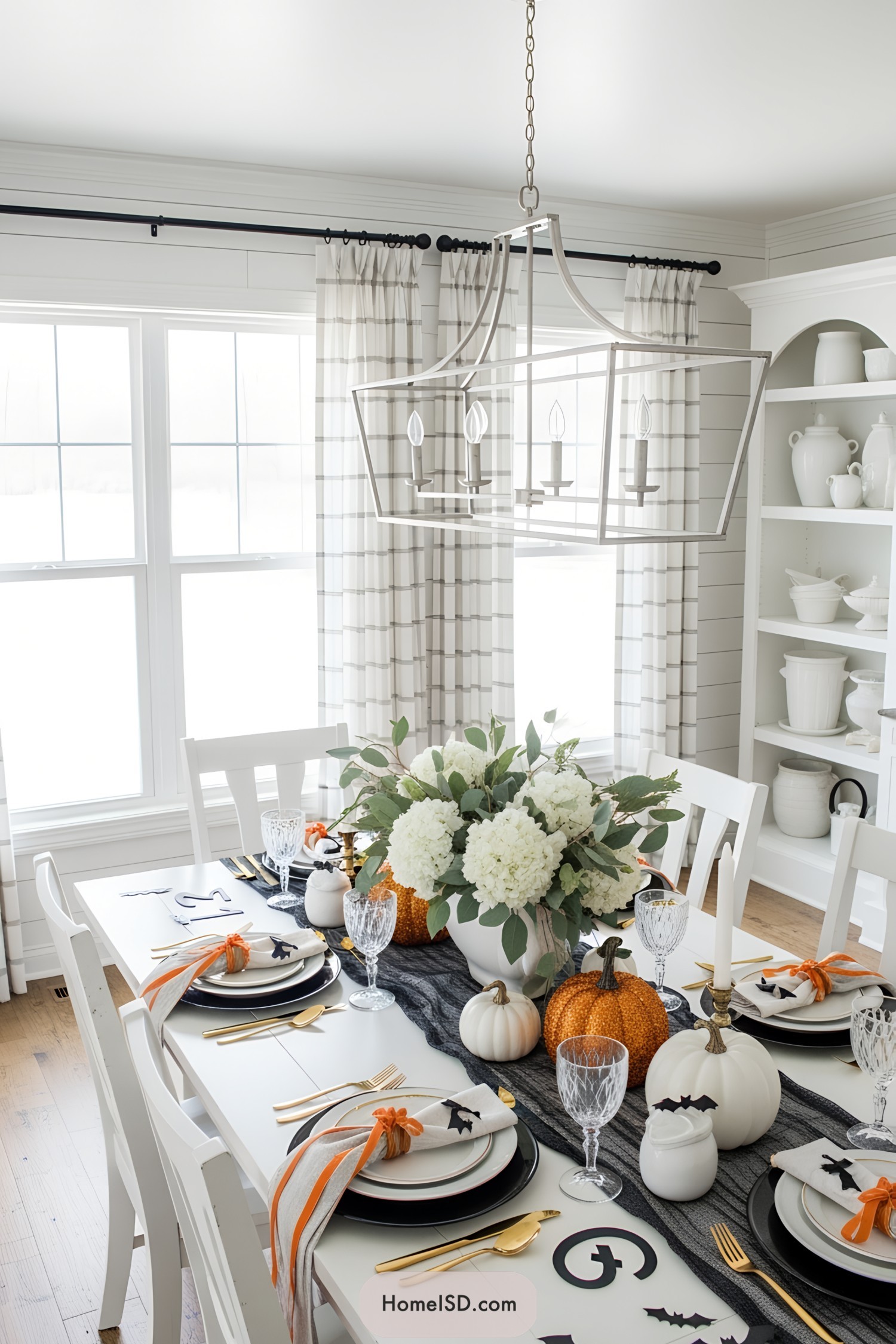 Elegant Halloween dining setup with pumpkins and floral centerpiece
