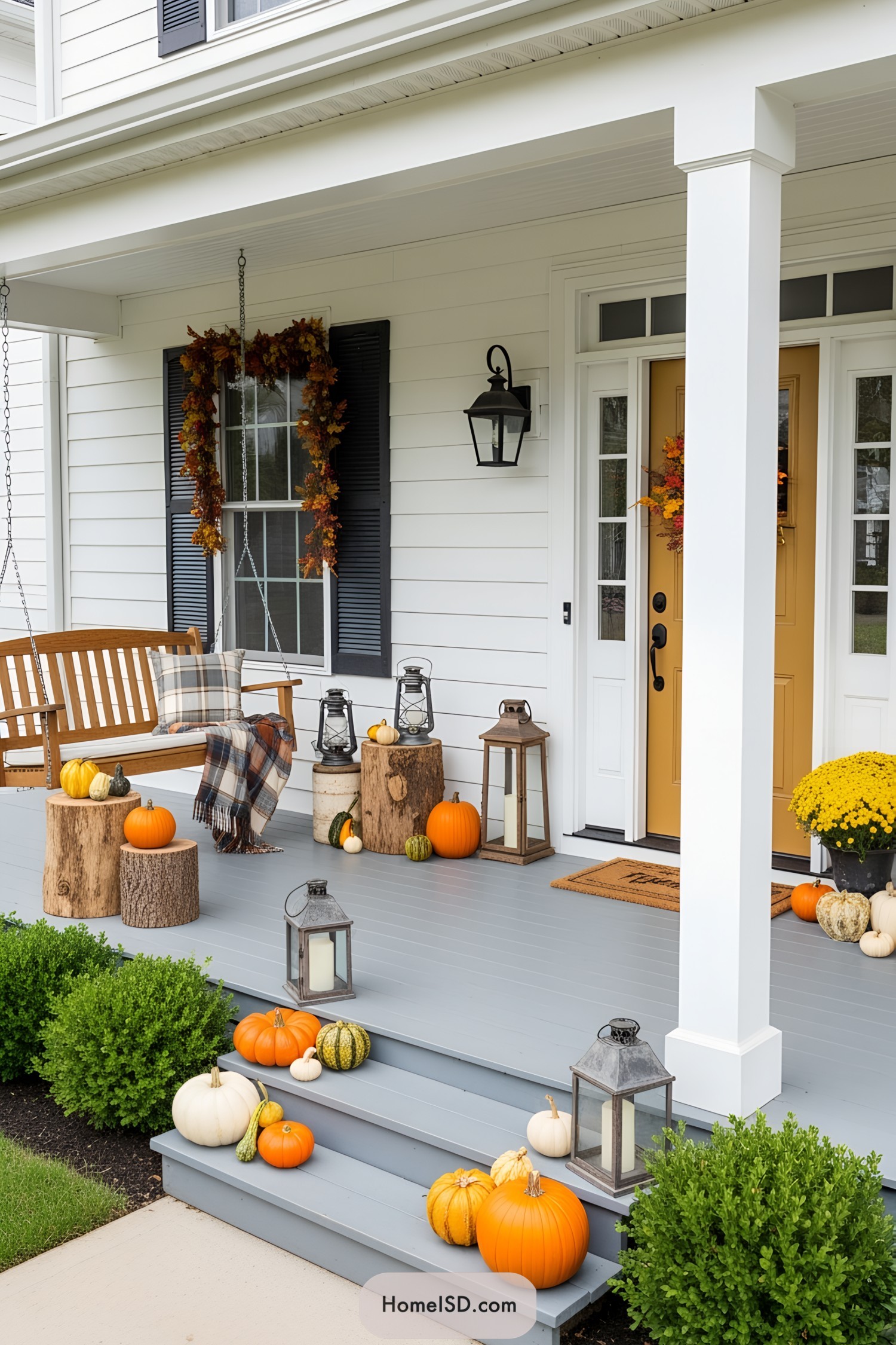 Charming front porch with pumpkins, lanterns, and a cozy swing
