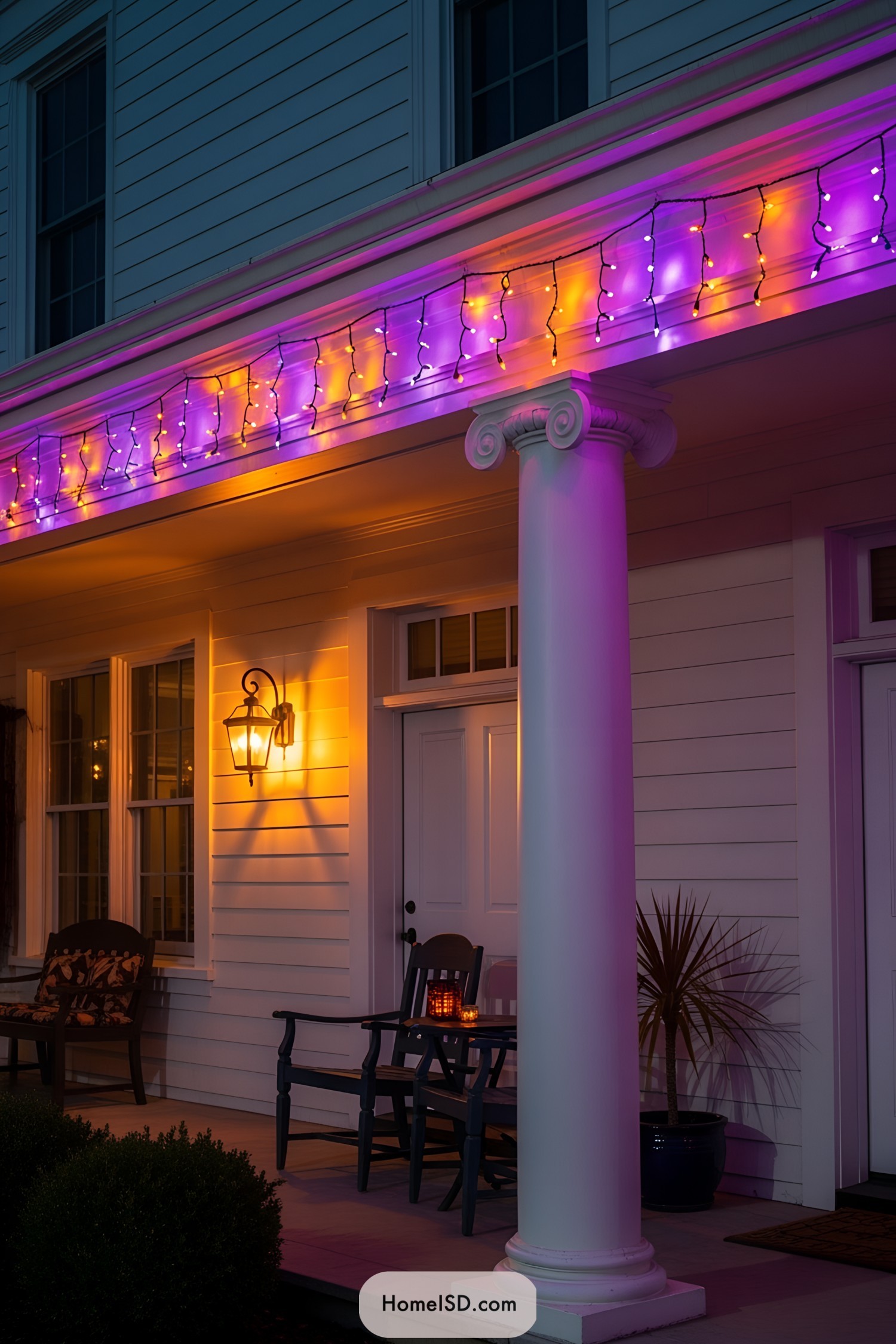 Halloween porch lights illuminate columns with orange and purple hues