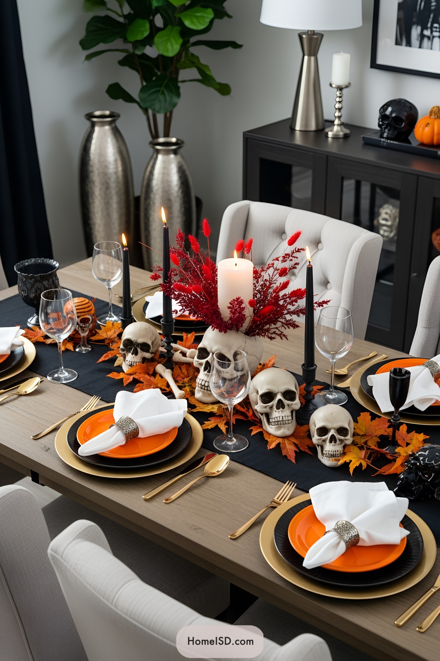 Halloween dining table with skulls, candles, and autumn leaves