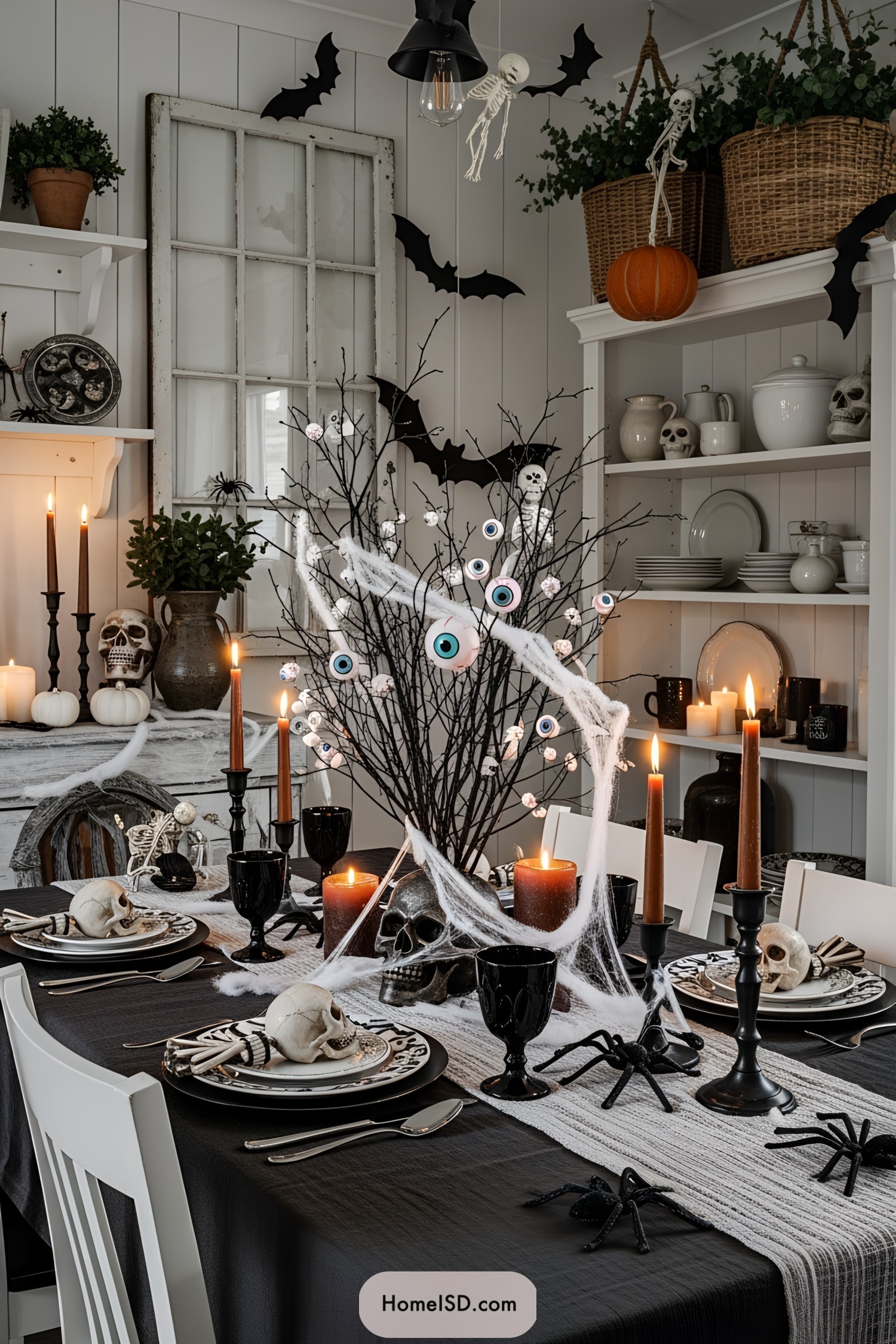 Halloween-themed table with skeletons, skulls, and candles