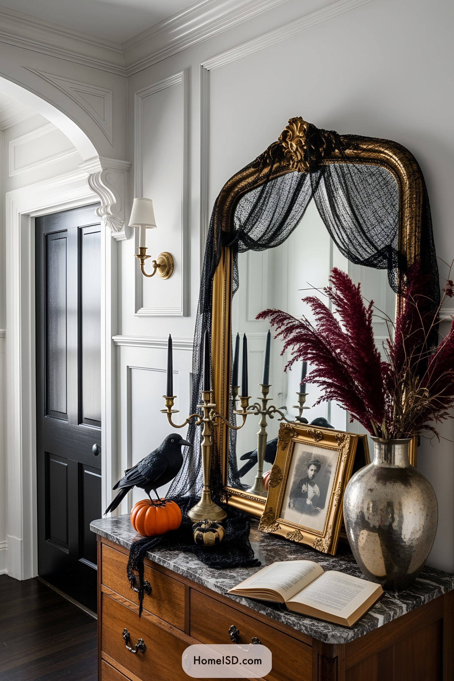 Classic vanity with Halloween decor, raven on pumpkin, and framed portrait