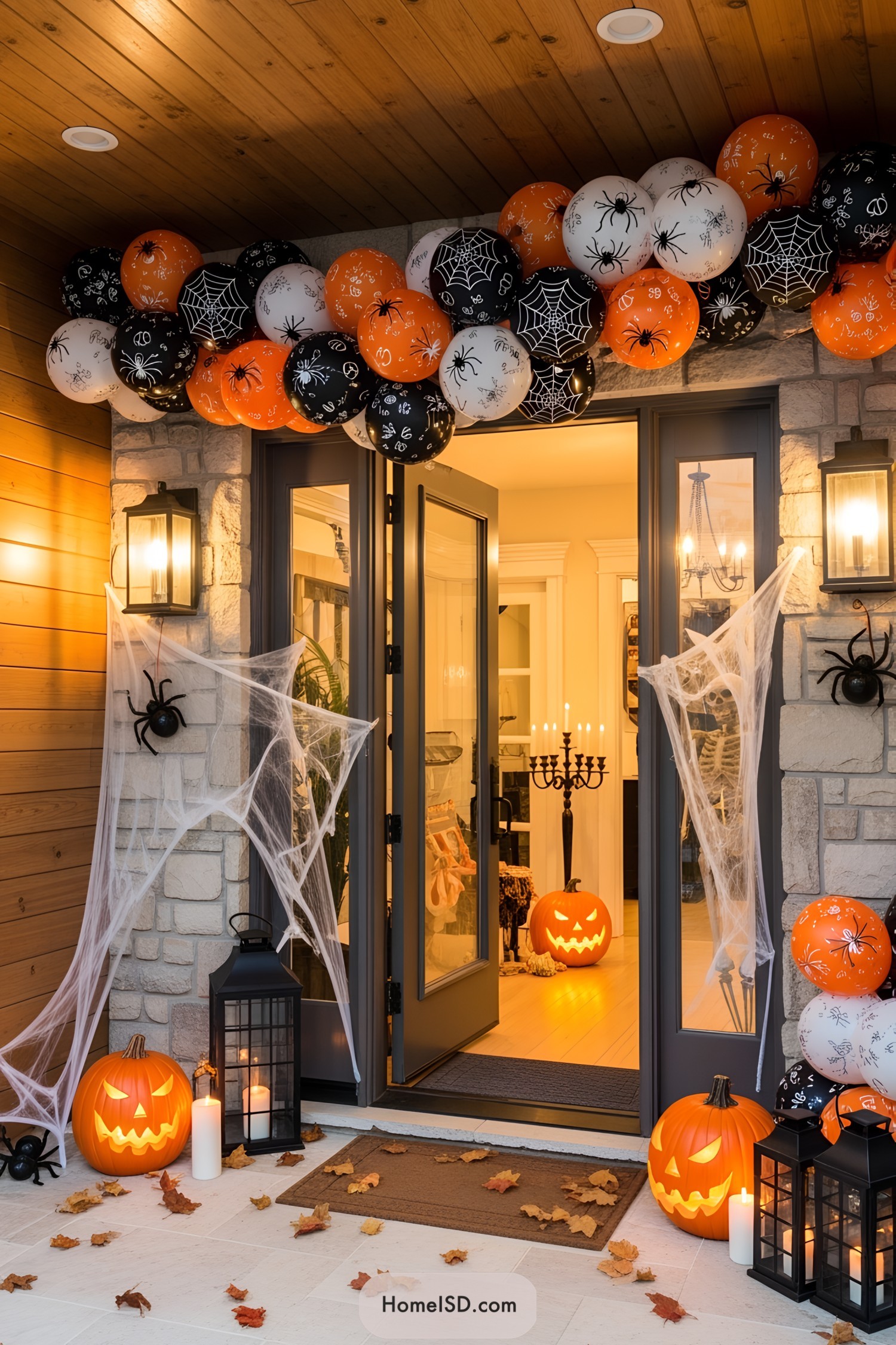 Halloween-themed entryway with balloons, jack-o'-lanterns, and cobwebs