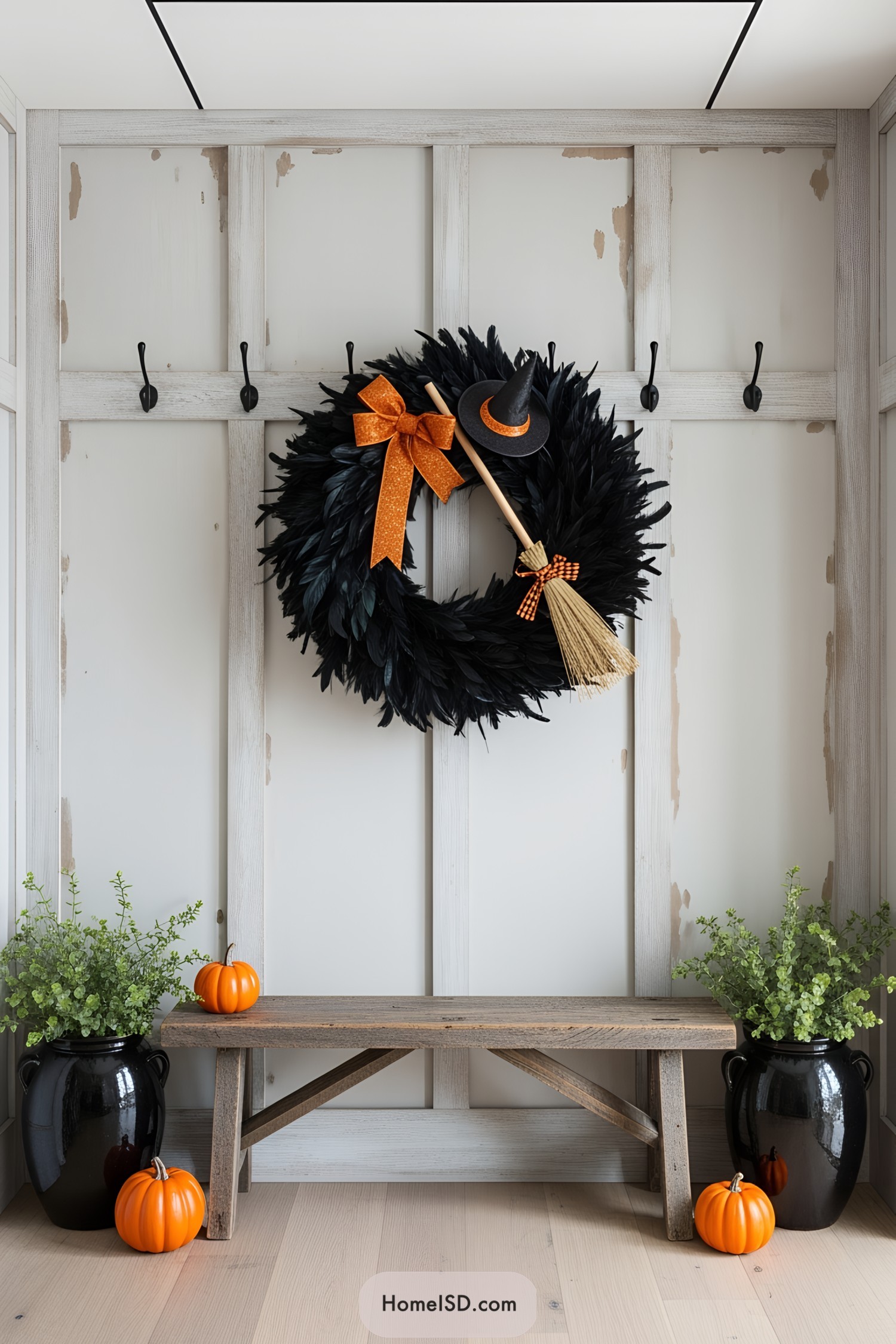 Halloween wreath with orange bow, witch hat, broomstick, and pumpkins