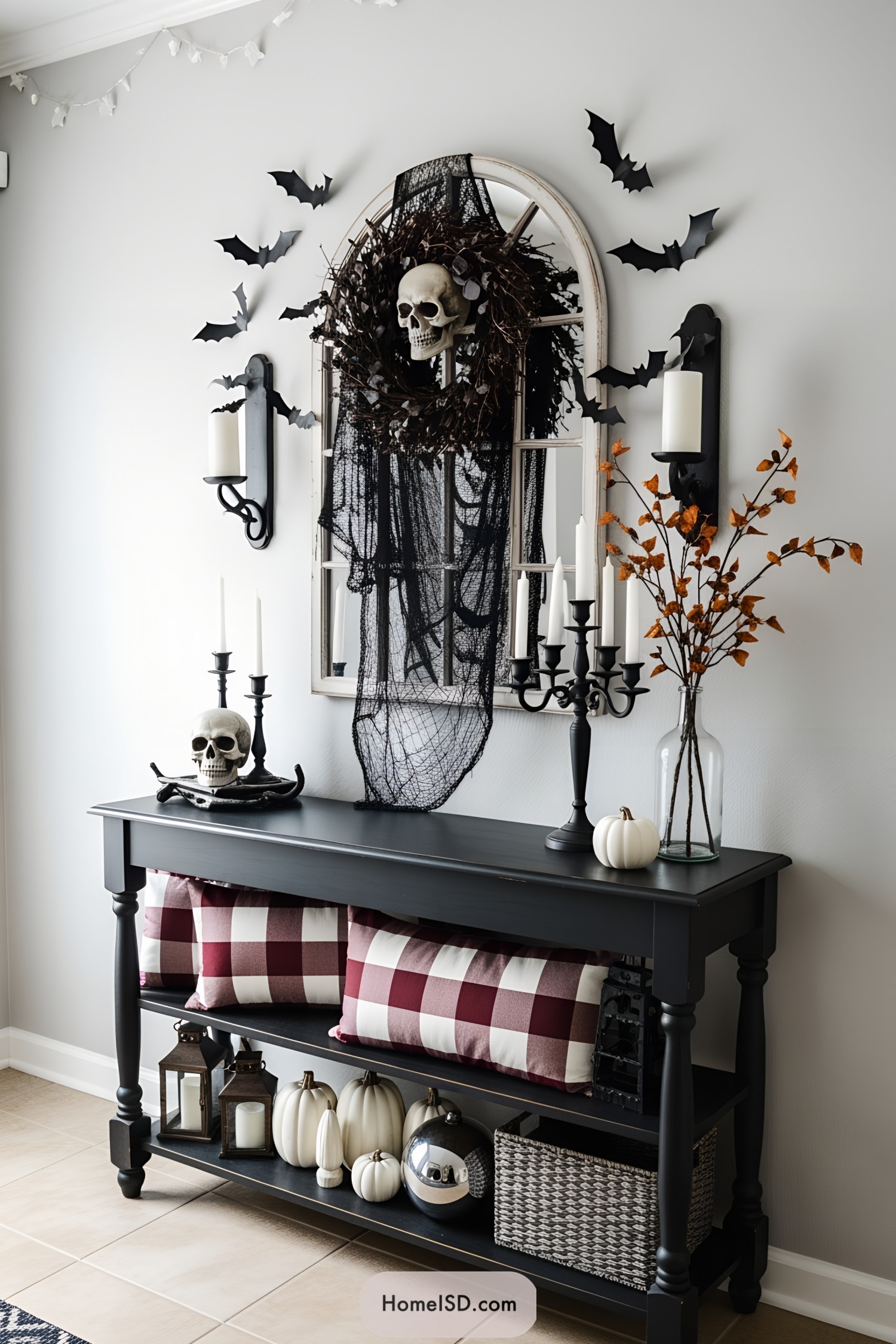 Halloween scene with a skull wreath, black table, and whimsical bat decorations