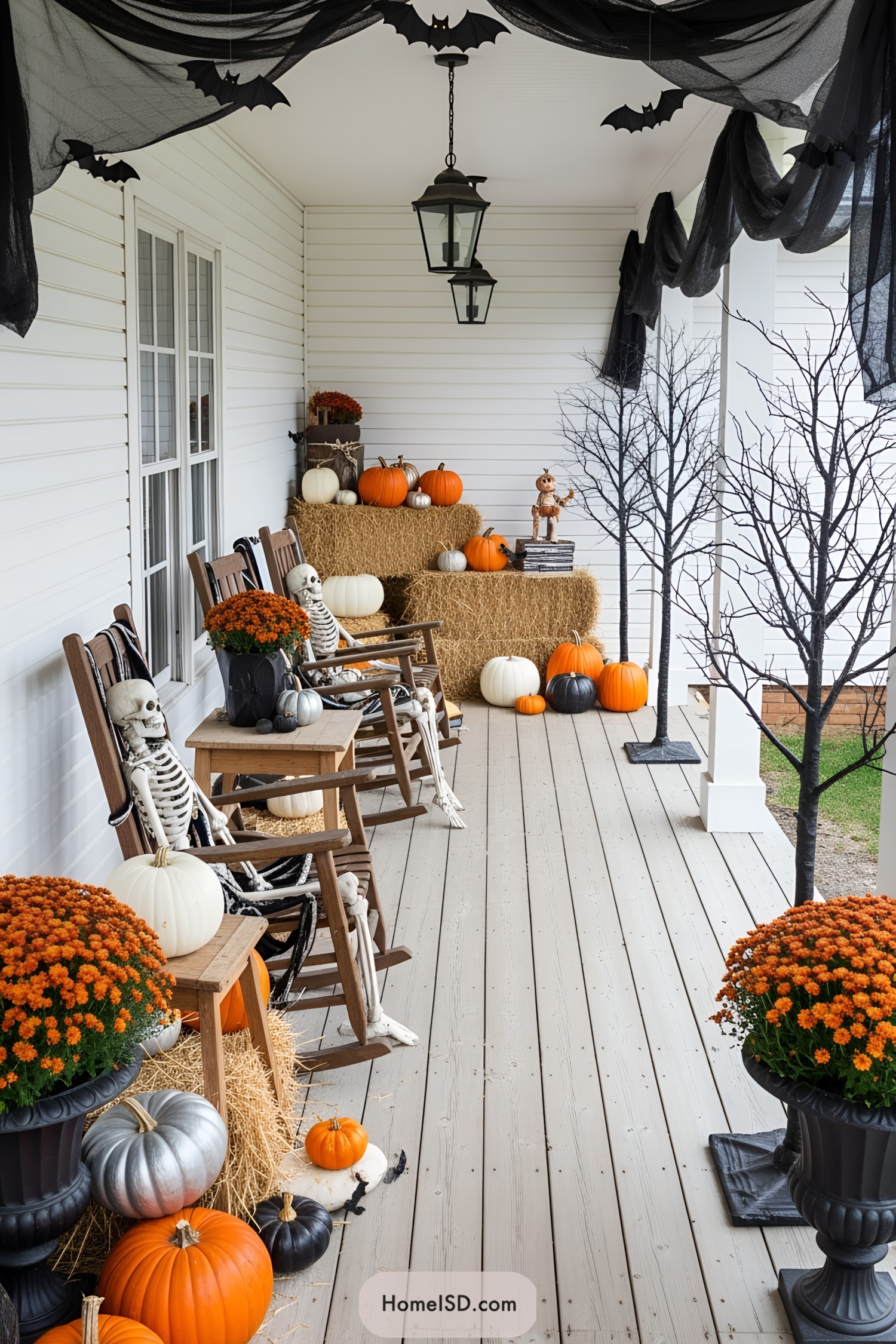 Festive porch with pumpkins, skeletons, and hay bales