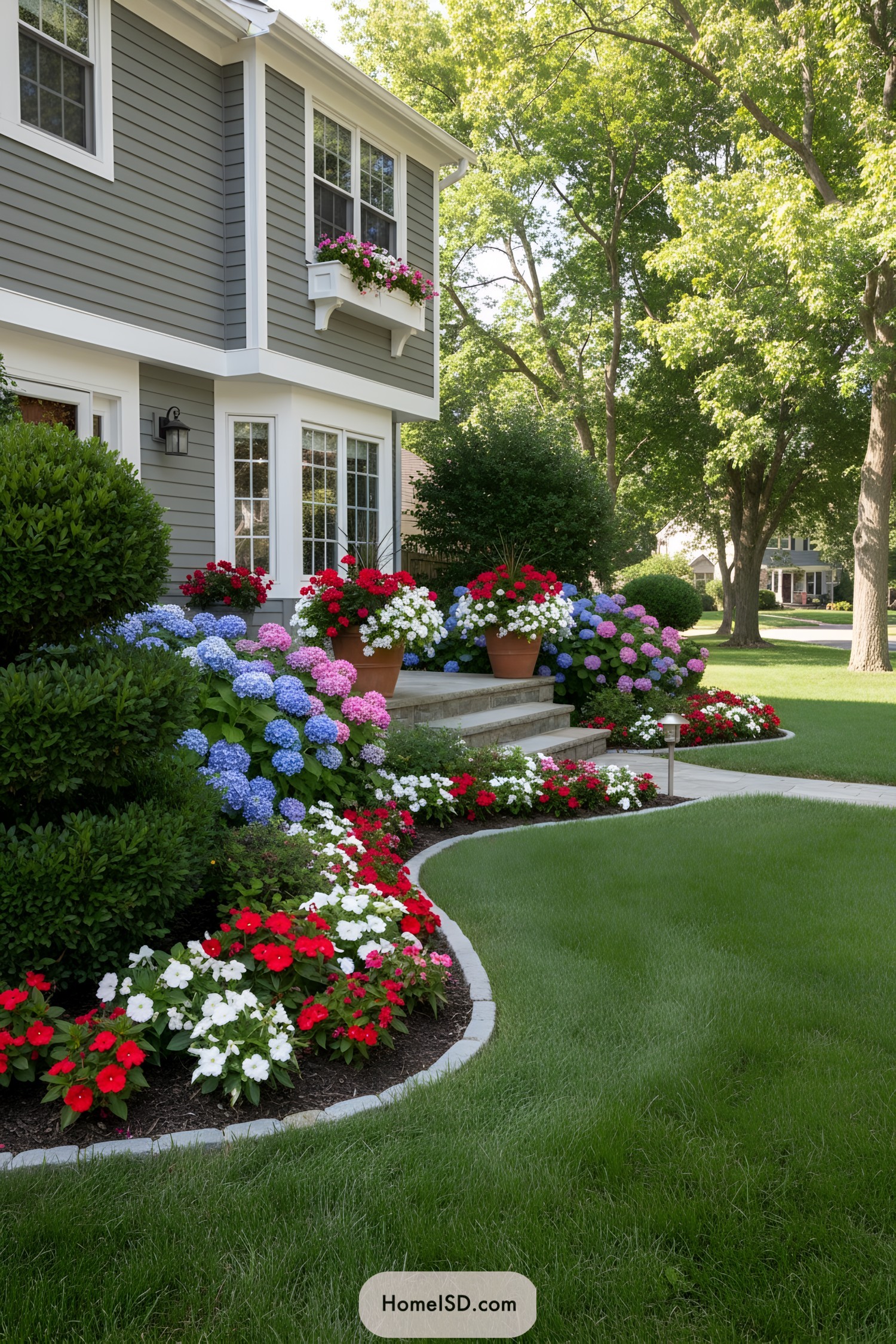 Colorful flowers and shrubs in front of a house with large windows