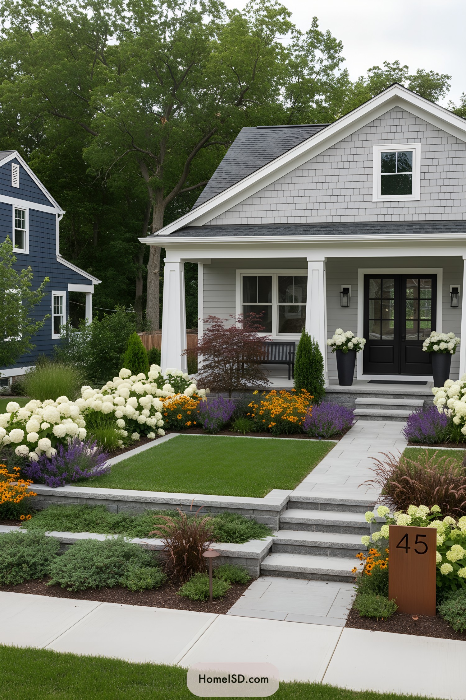 Terraced front yard with pale pavers, hydrangea masses, manicured lawn, and rusted address sign