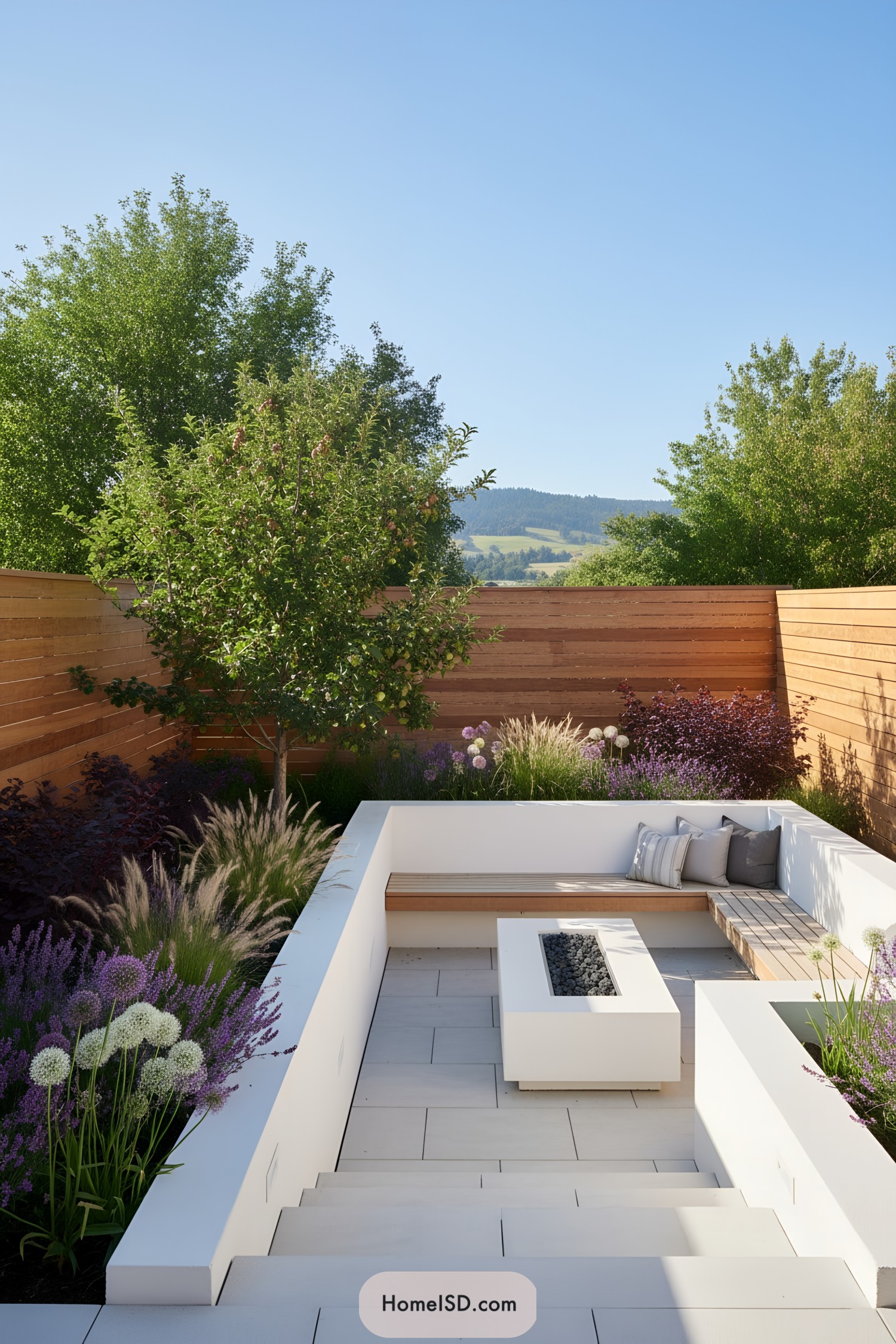 Sunken patio with white benches, wood slat seat, and rectangular fire pit amid grasses