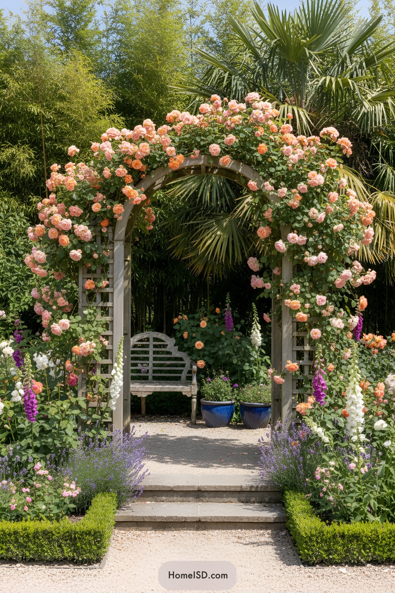 Wooden arch draped in peach roses with a bench beyond