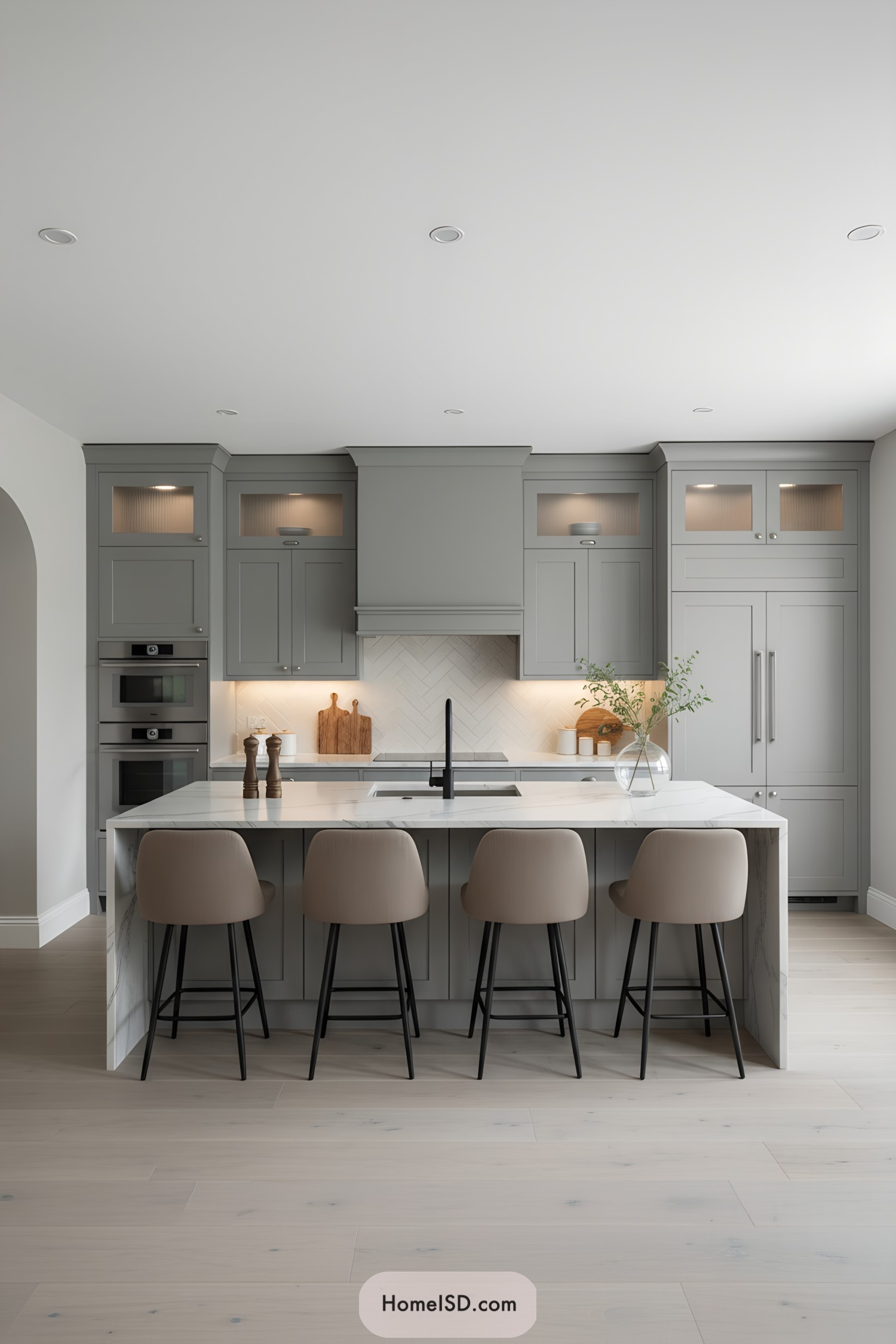 Gray shaker kitchen with marble island and herringbone backsplash
