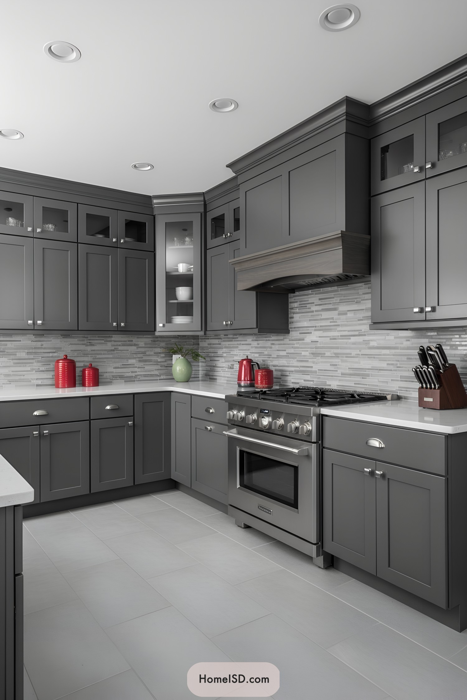 Sleek grey shaker cabinets with glass uppers, stainless range, and mosaic backsplash