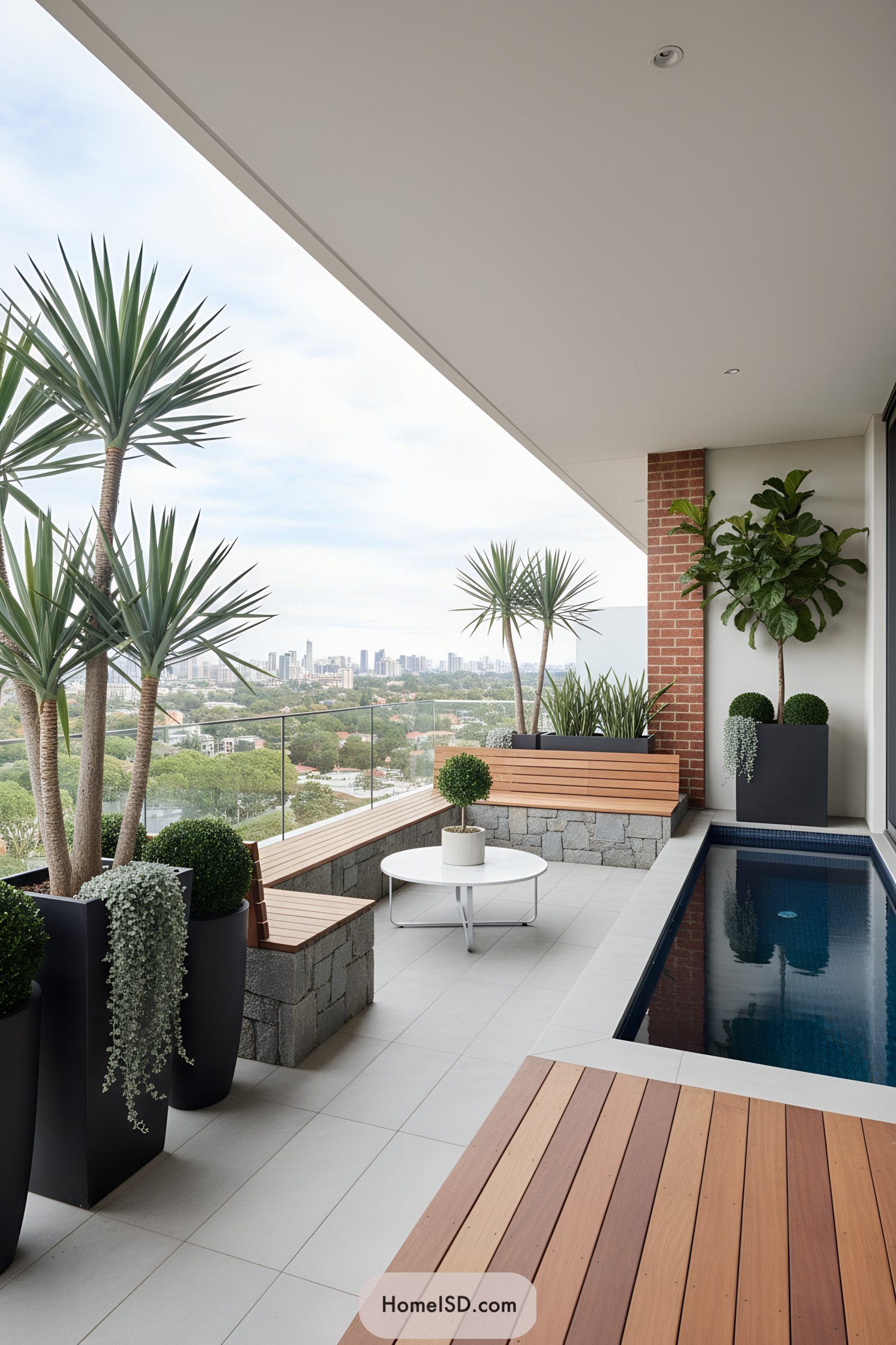 Modern balcony with slim plunge pool, wood benches, and sculptural potted plants overlooking a distant city skyline