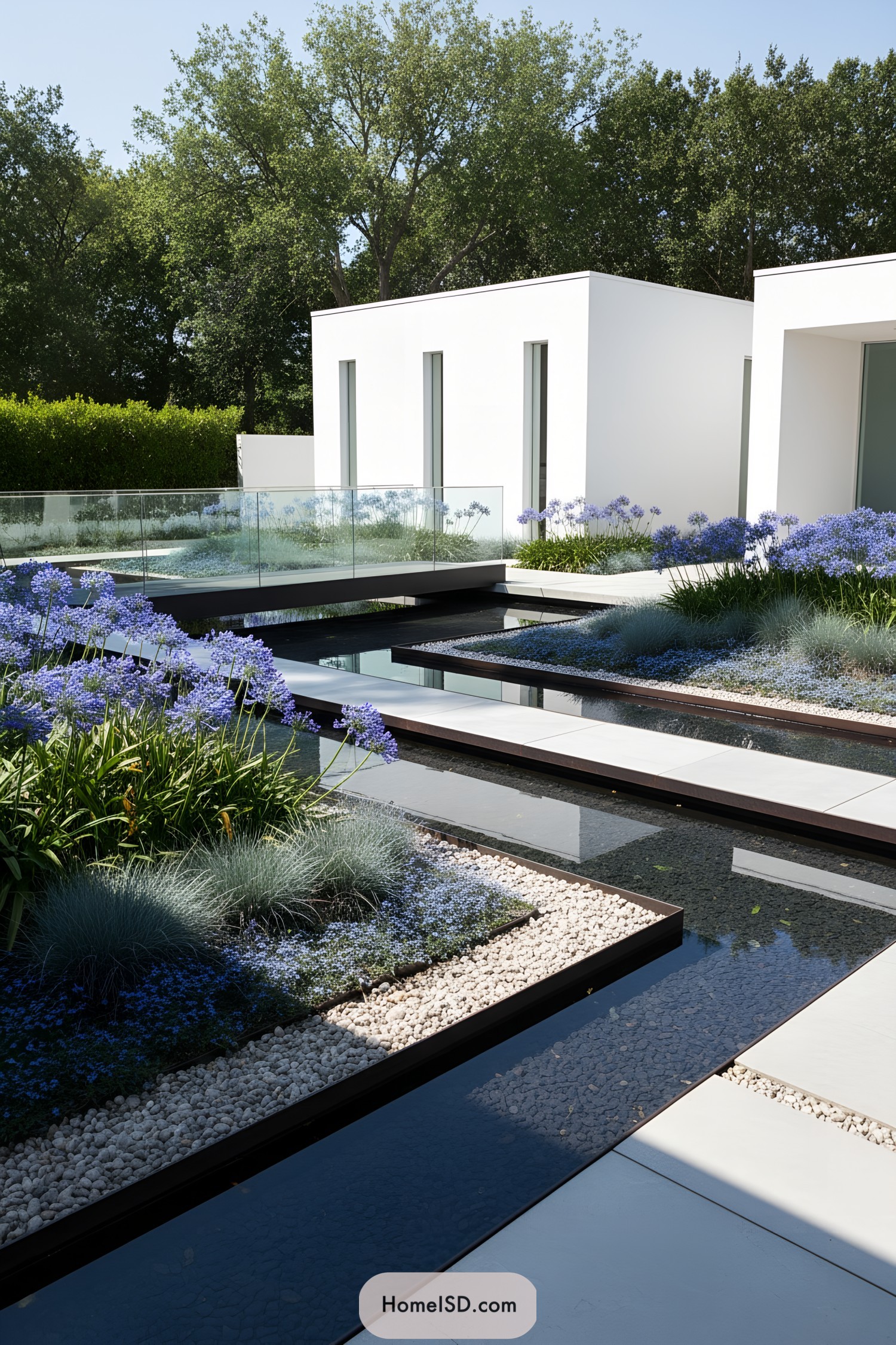 Modern white courtyard with blue flower beds and sleek reflecting pools