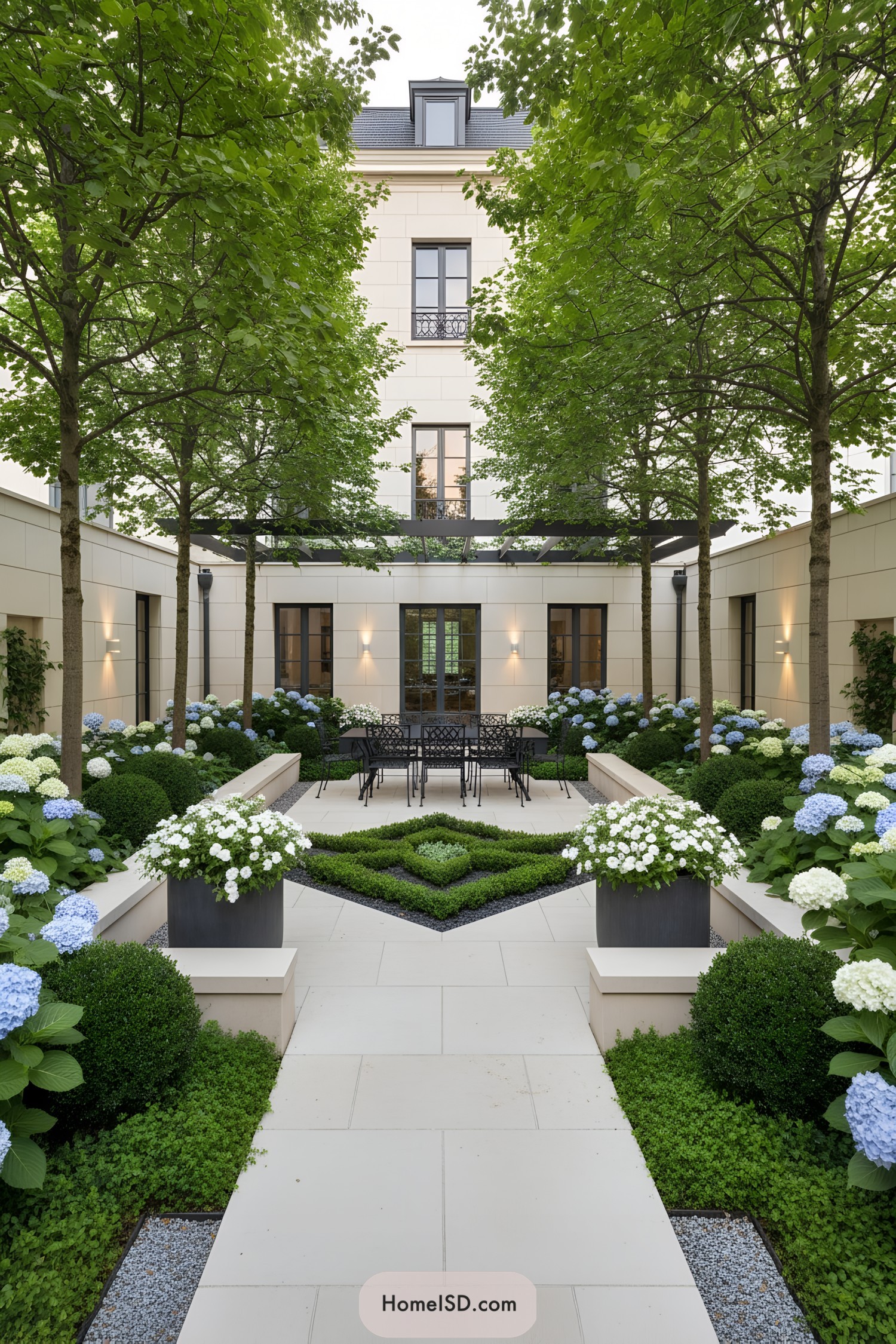 Formal courtyard garden with geometric hedges, hydrangeas, and dining set