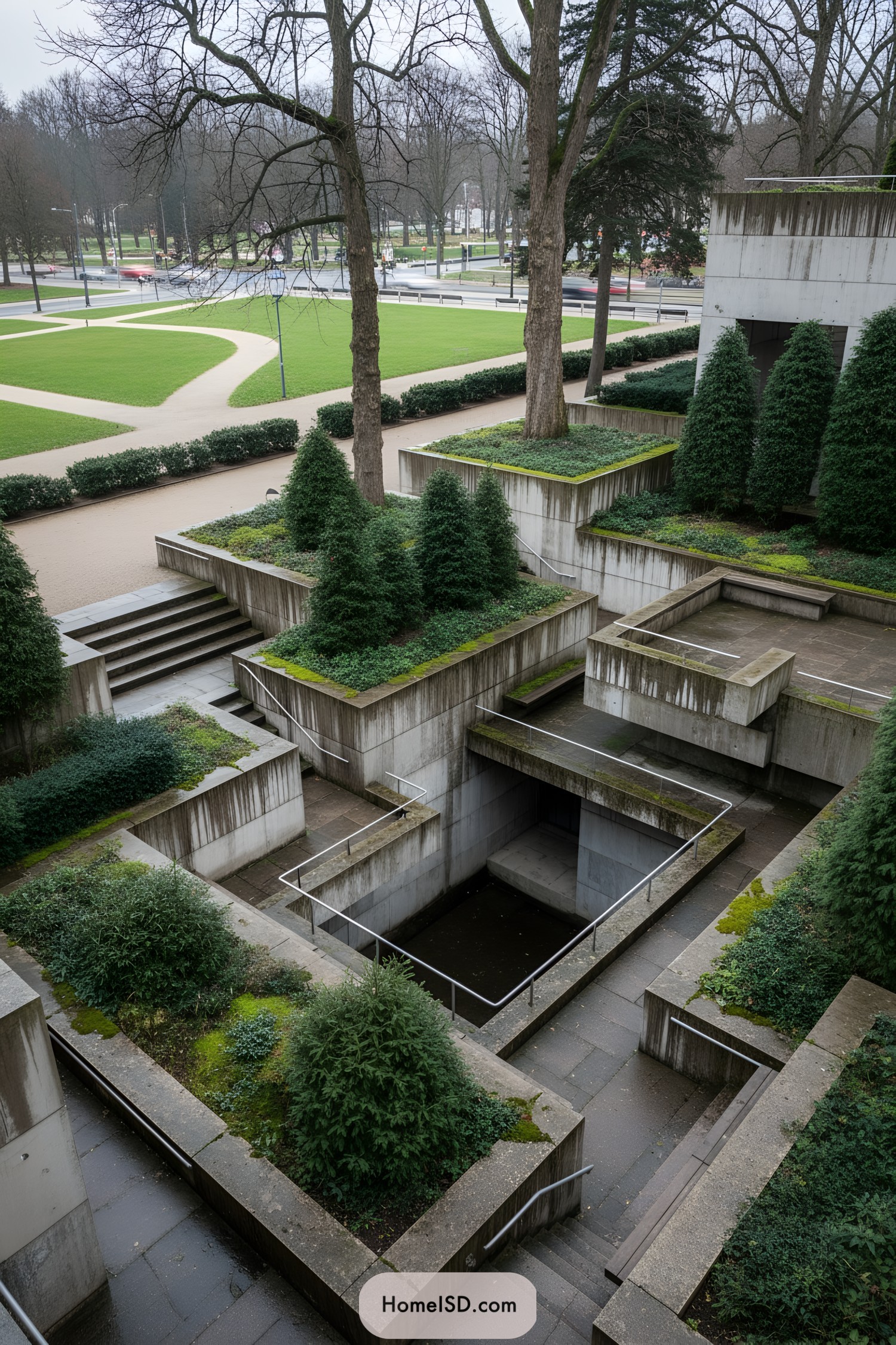 Tiered concrete courtyard with evergreen plantings and sunken walkways