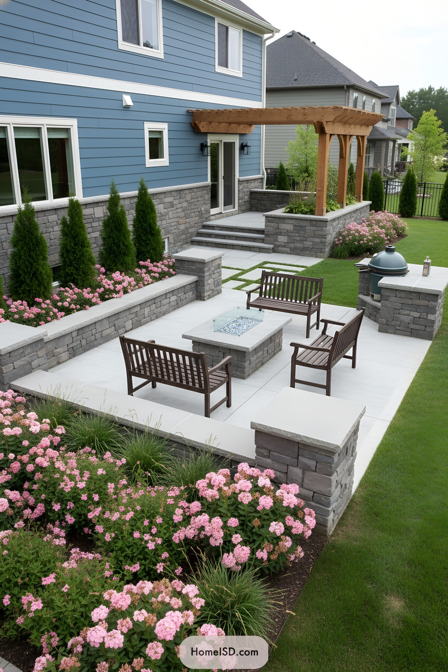 Modern stone patio with wood pergola and pink flower borders