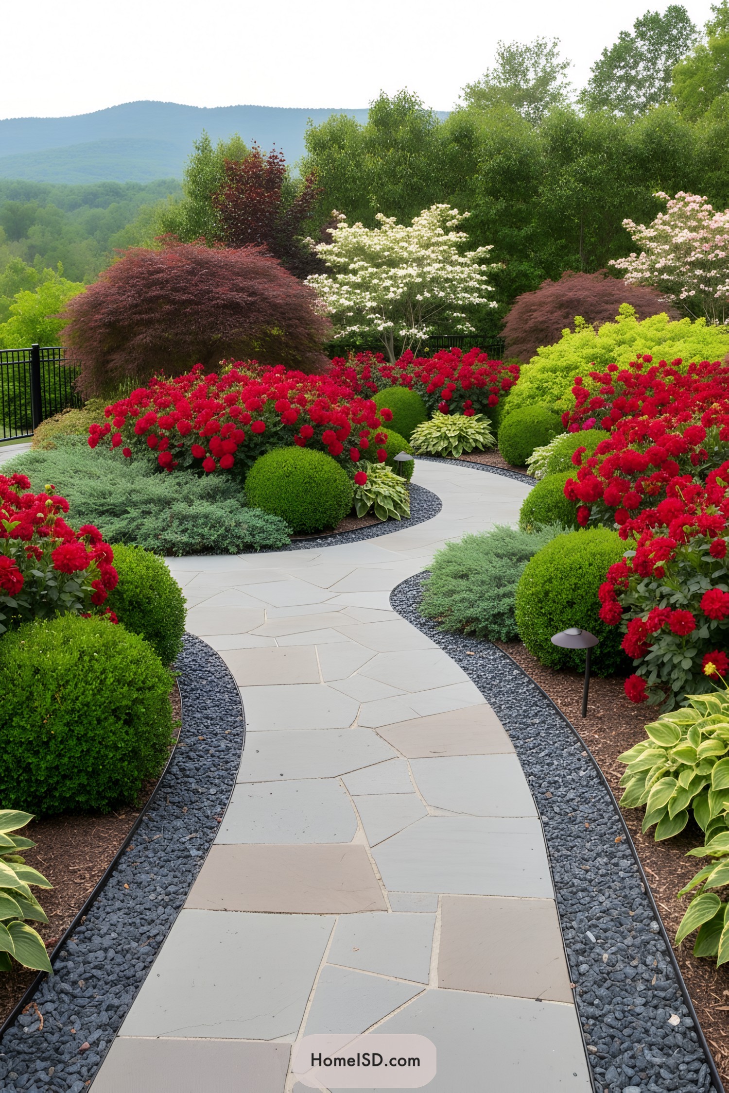 Curving stone path through lush red flowers
