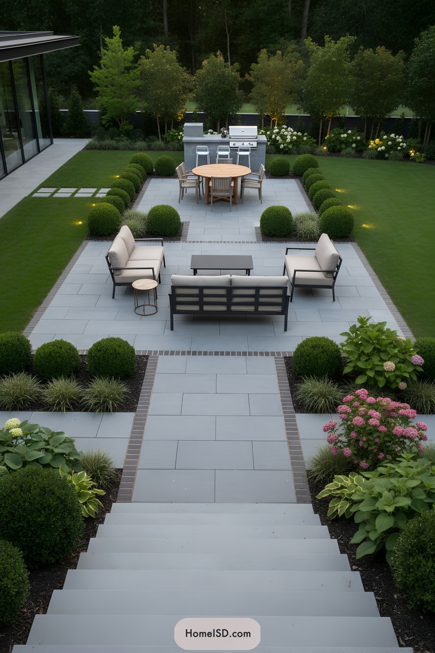 Modern tiered patio with lawn and boxwoods