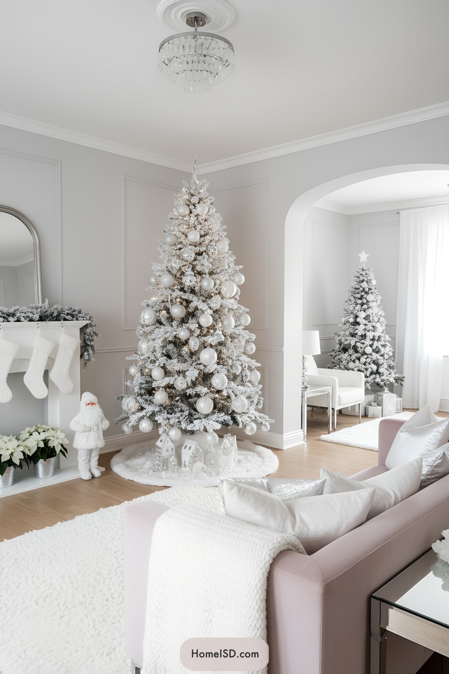 White flocked Christmas tree with large pearl ornaments in a soft gray living room