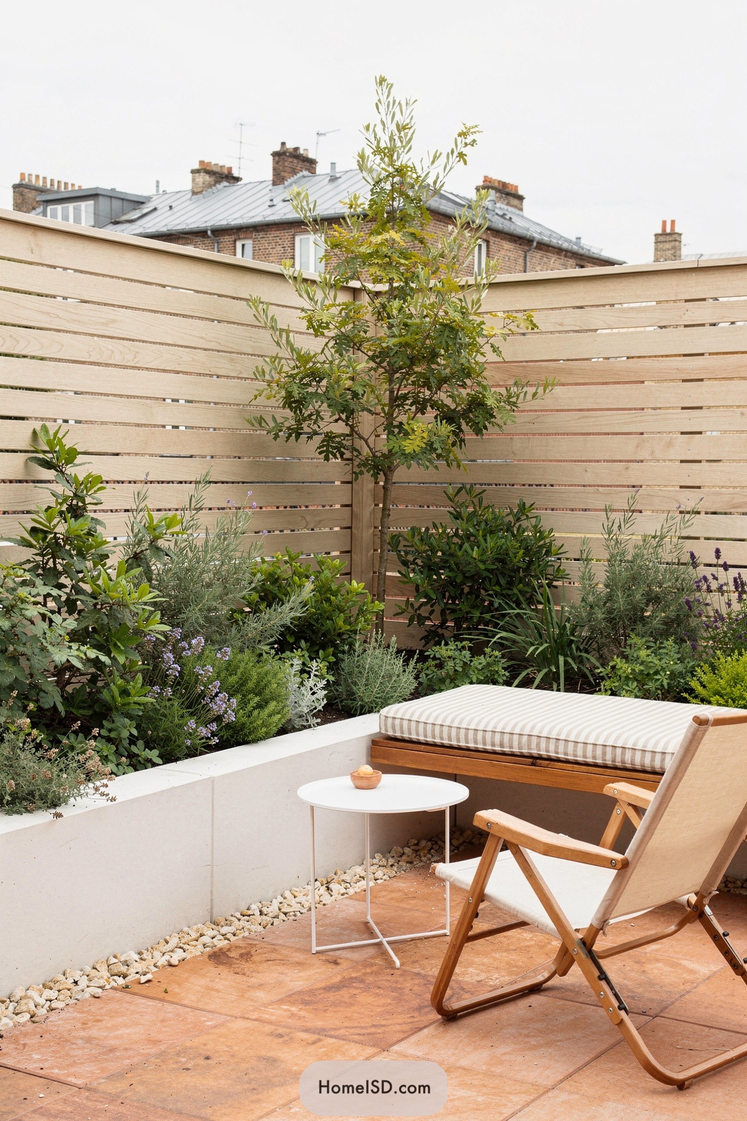 Small patio with slatted wood fence, raised planter, and built‑in bench seating