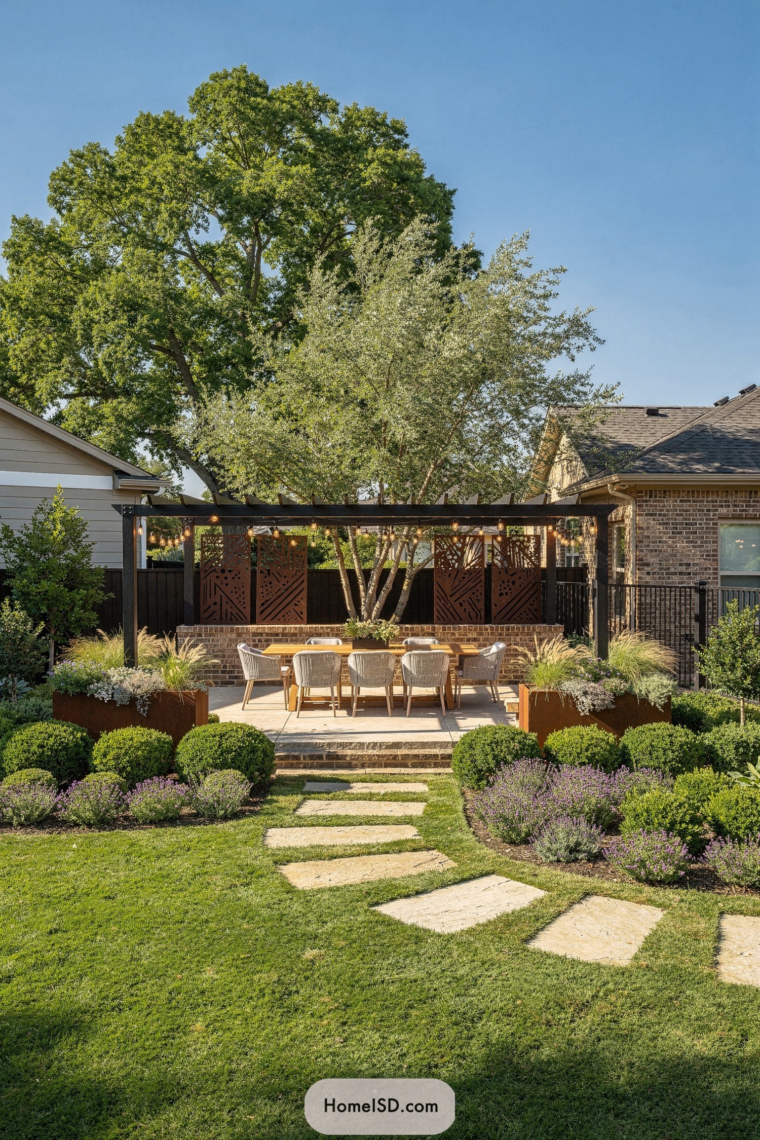 Backyard pergola dining area framed by lush plantings and stone stepping path