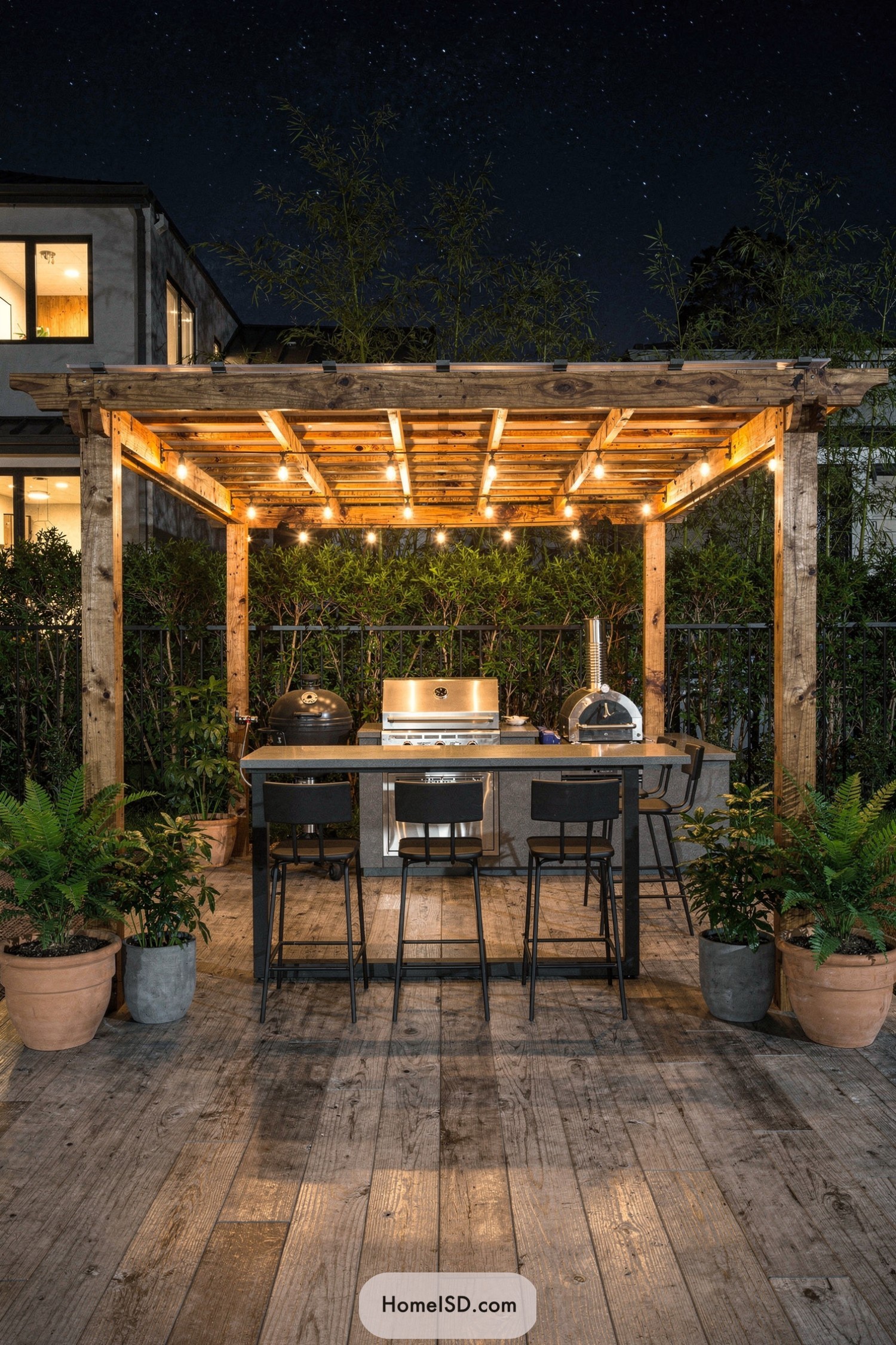 Wood pergola BBQ bar with string lights at night