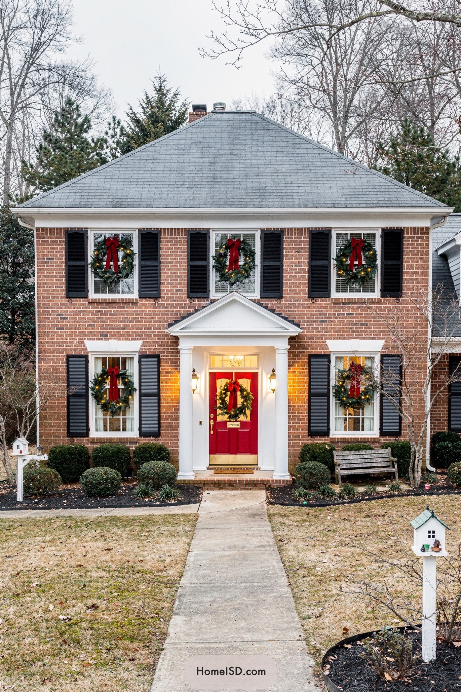 Brick house with matching lit Christmas wreaths