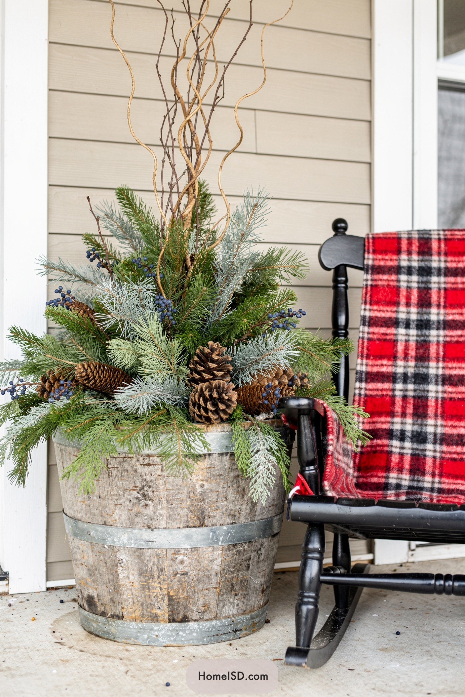 Rustic winter porch planter beside rocking chair