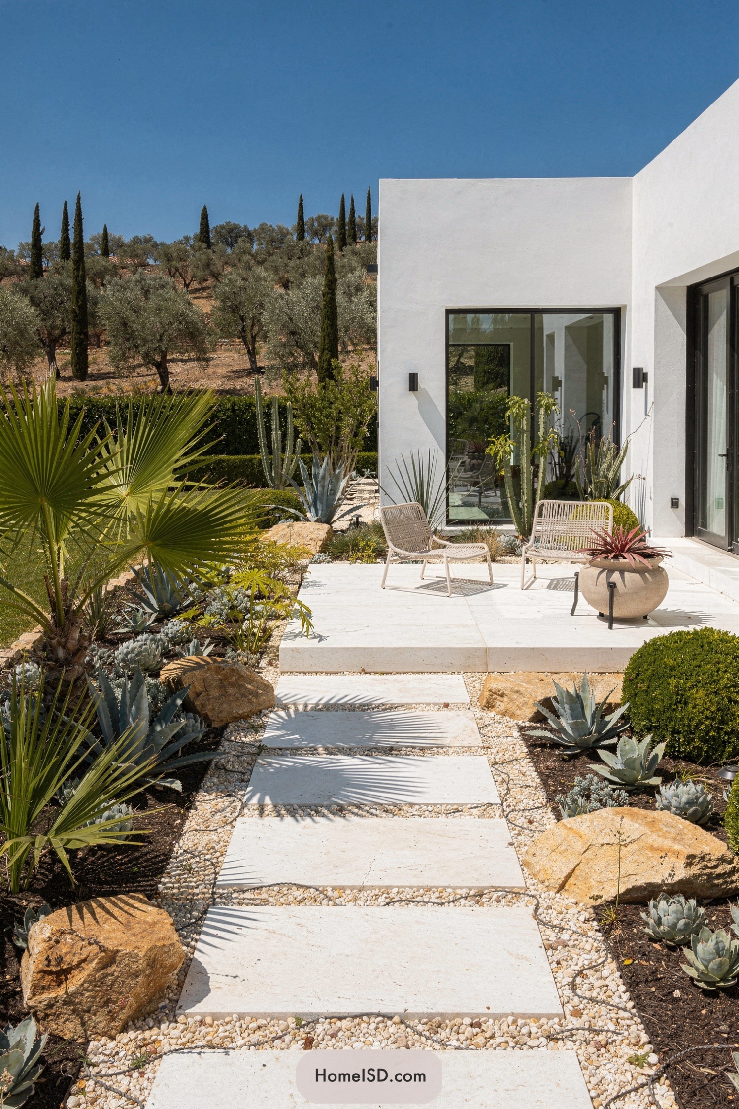 Modern Mediterranean front yard with wide stone path and succulents