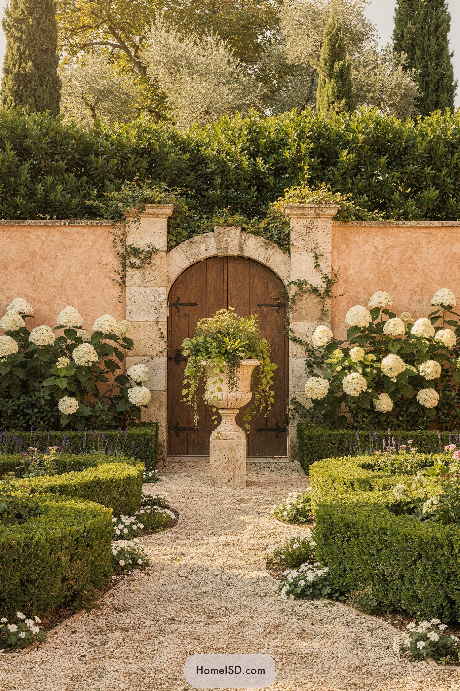 Mediterranean walled garden with arched gate and layered hedges