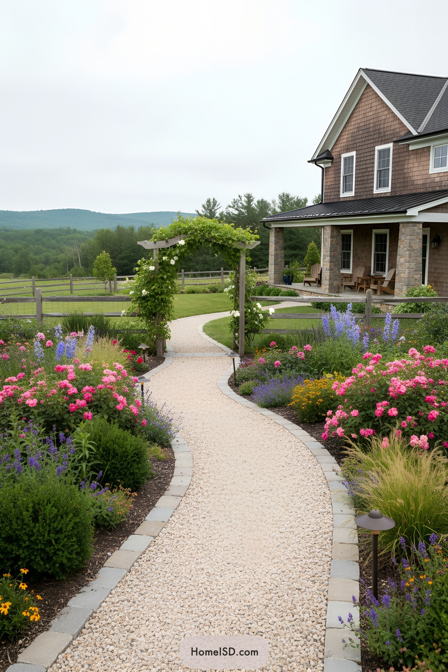 Curving gravel path with flower beds and arbor leading to farmhouse porch