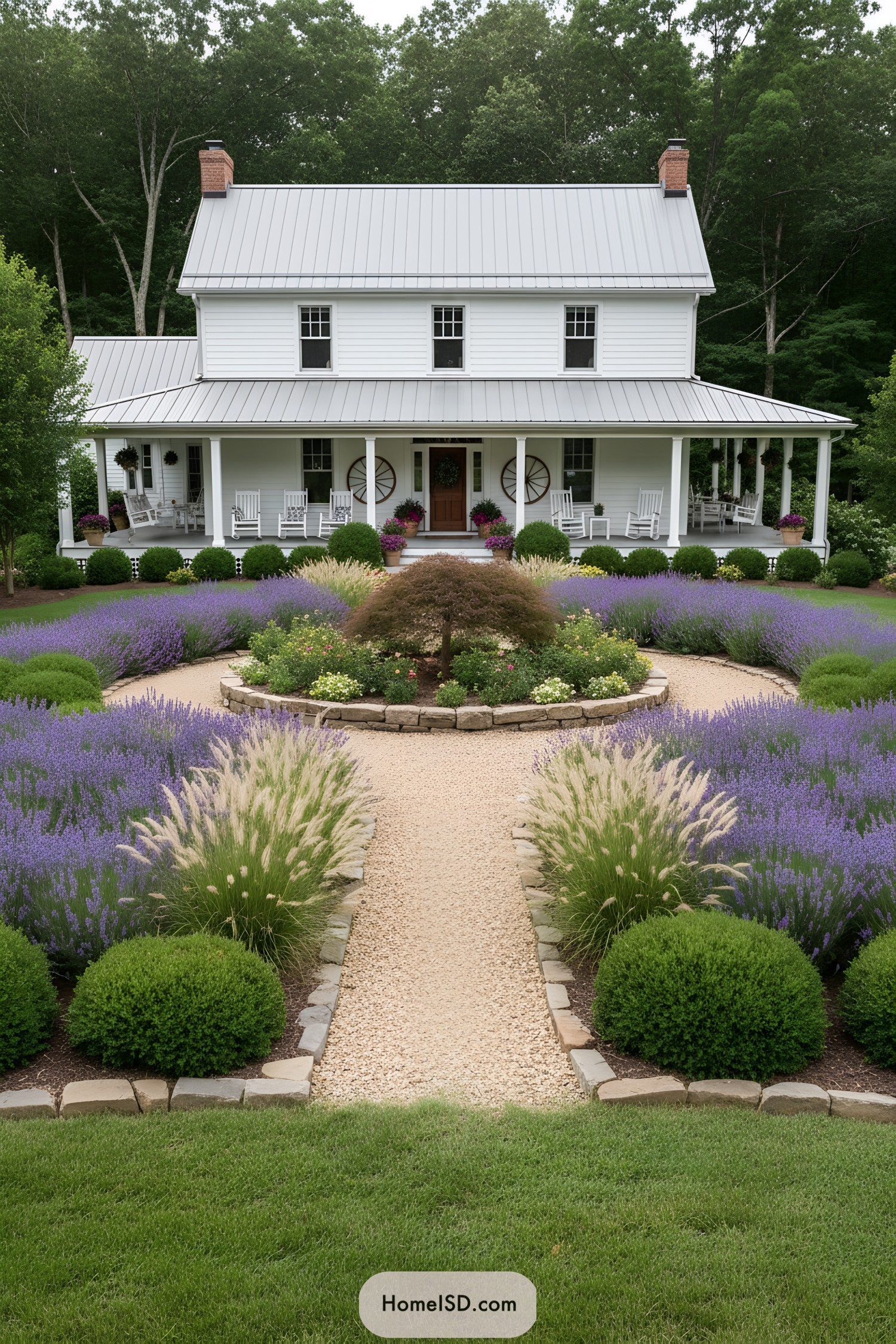 Symmetrical gravel path bordered by lavender and shrubs leading to a white farmhouse with a wide porch