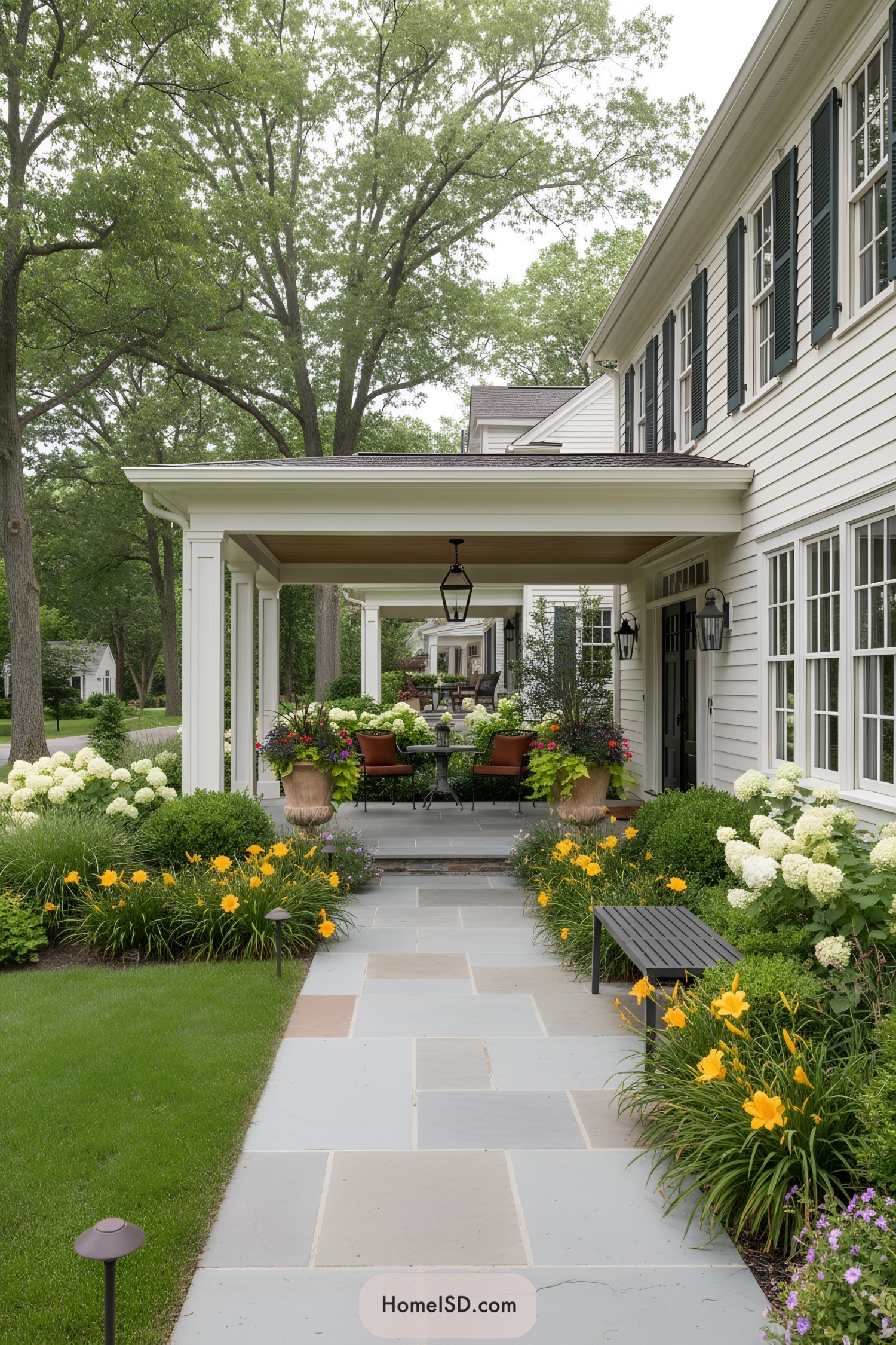 Farmhouse front porch with flagstone walkway and colorful layered plantings